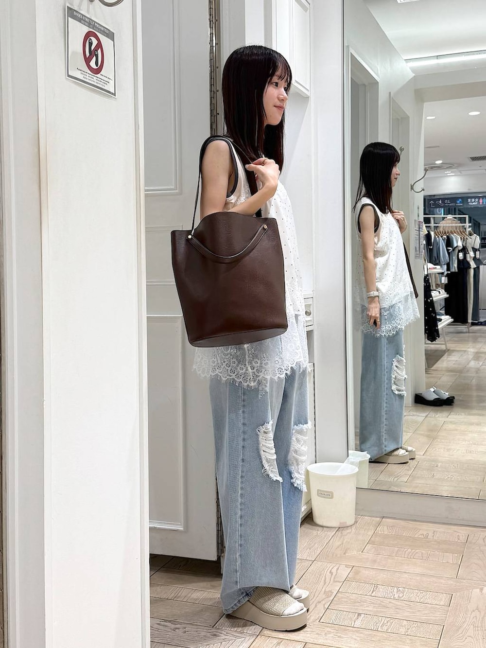 ホワイト系のタンクトップ、ブルー系のデニムパンツ、ホワイト系のサンダルを着用したレディースの夏コーディネートの2枚目の写真