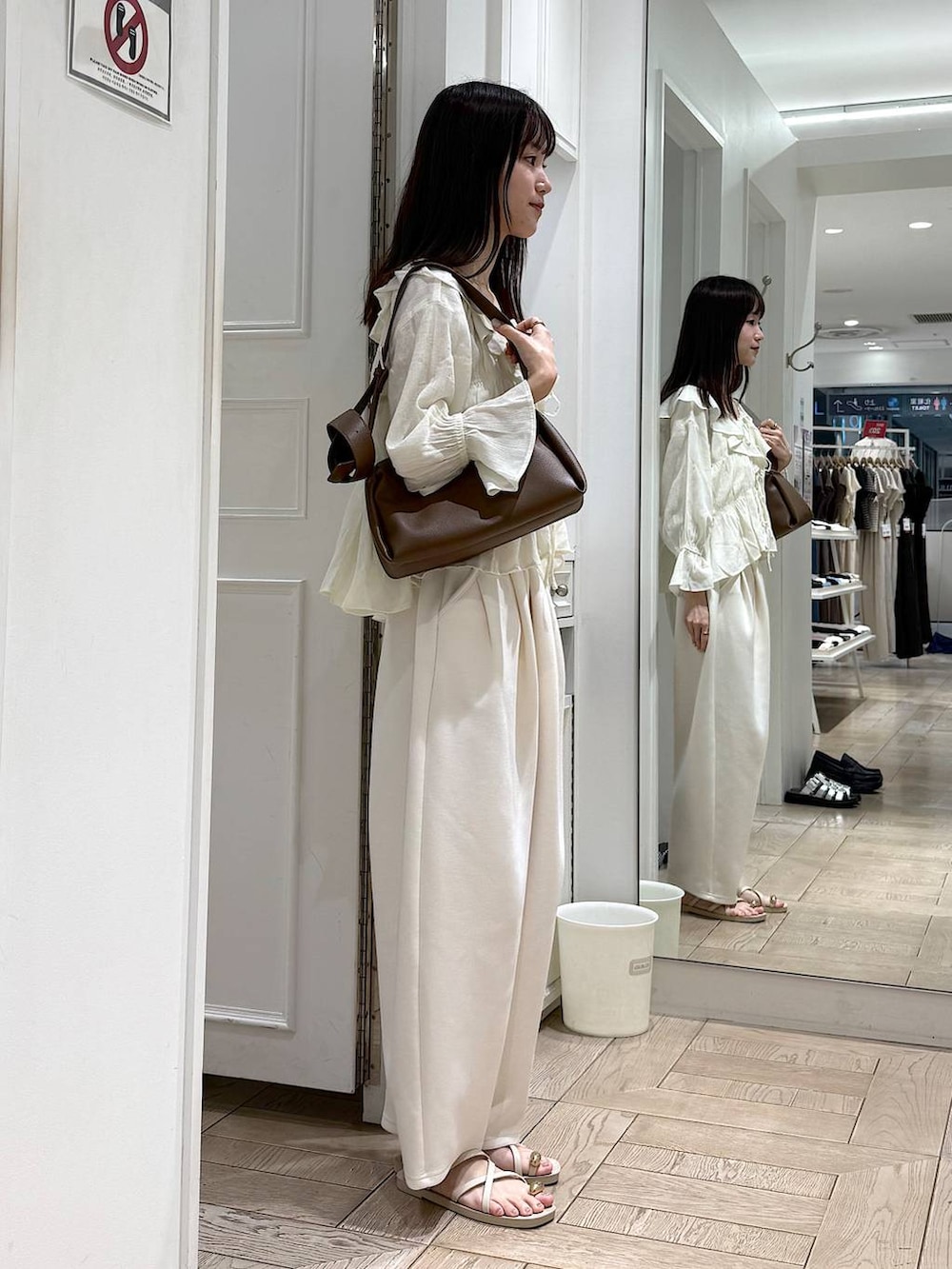 ベージュ系のスウェットパンツ、ホワイト系のサンダル、ホワイト系のシャツ/ブラウスを着用したレディースの夏コーディネートの2枚目の写真