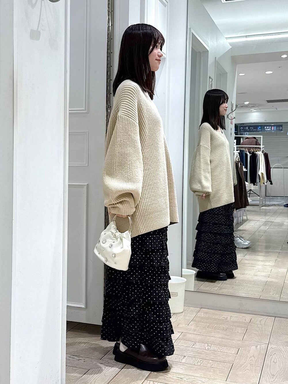 その他のスカート、ブラウン系のサンダル、ホワイト系のハンドバッグを着用したレディースの冬コーディネートの2枚目の写真