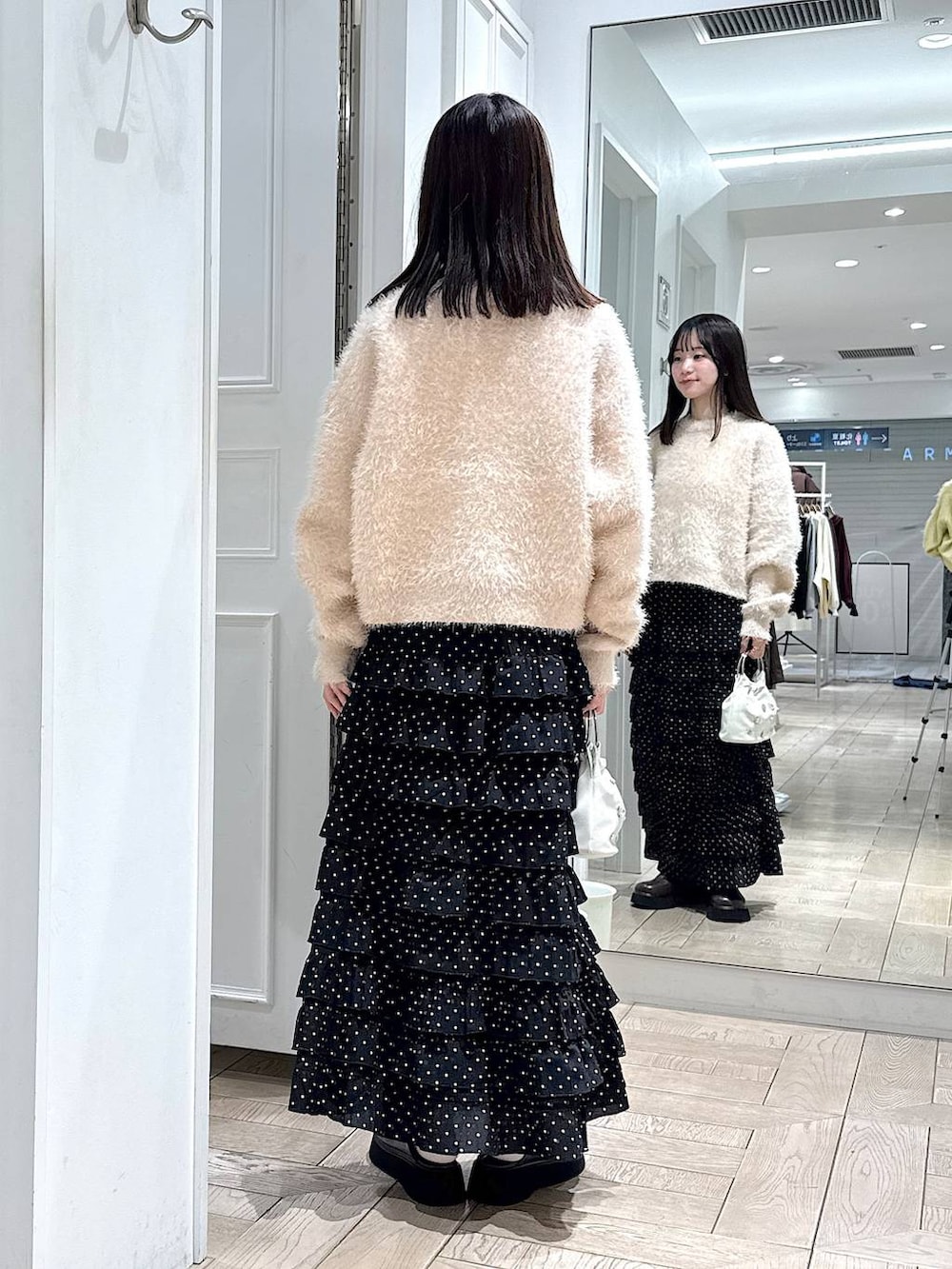 その他のスカート、ブラウン系のサンダル、ホワイト系のハンドバッグを着用したレディースの冬コーディネートの3枚目の写真