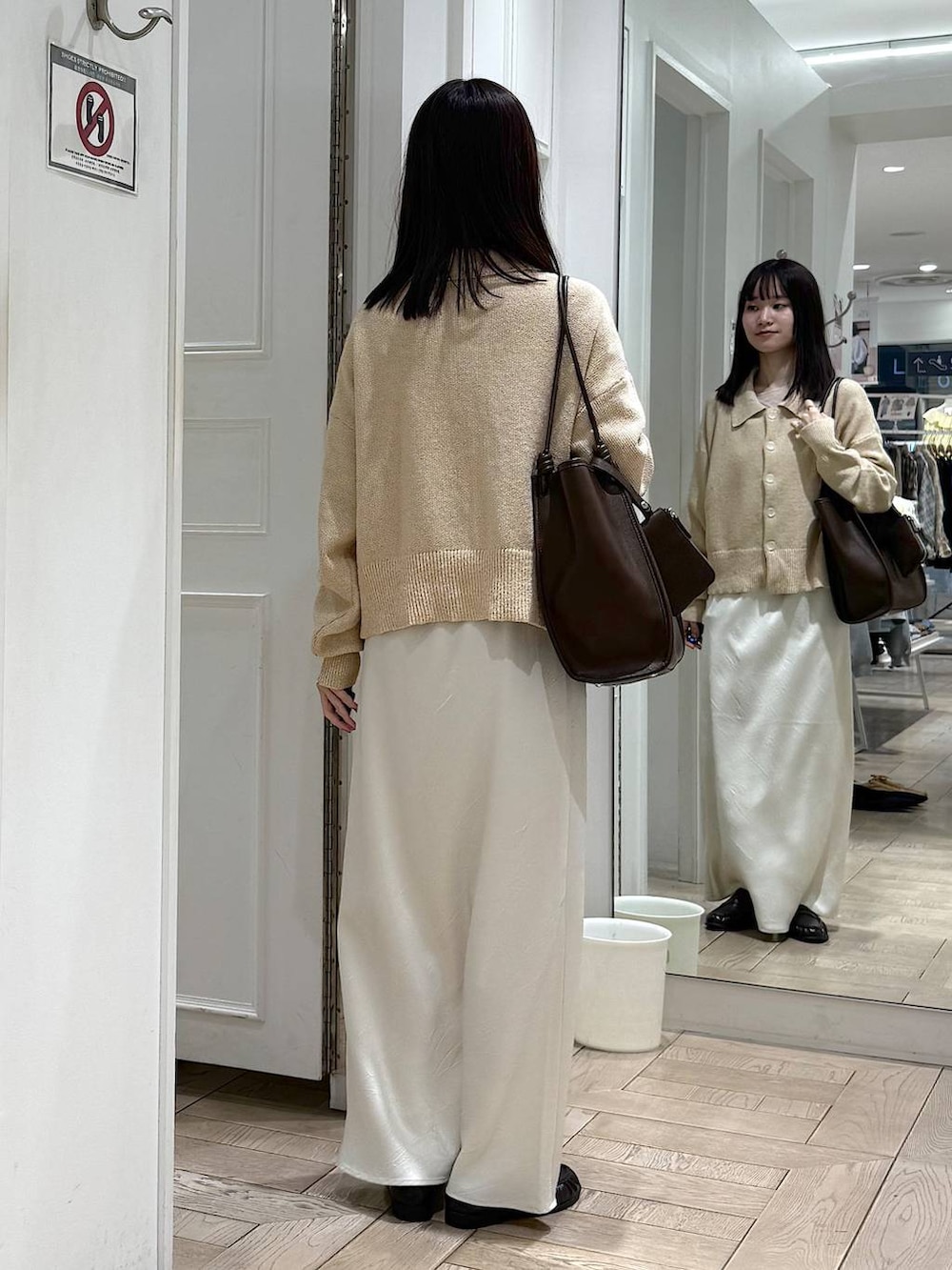 ホワイト系のスカート、ブラウン系のローファー、ブラウン系のトートバッグを着用したレディースの春コーディネートの3枚目の写真