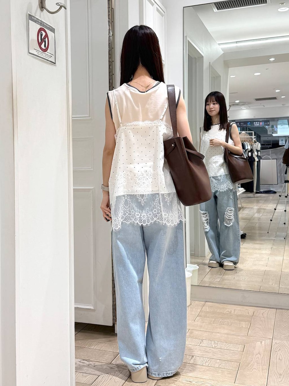 ホワイト系のタンクトップ、ブルー系のデニムパンツ、ホワイト系のサンダルを着用したレディースの夏コーディネートの3枚目の写真