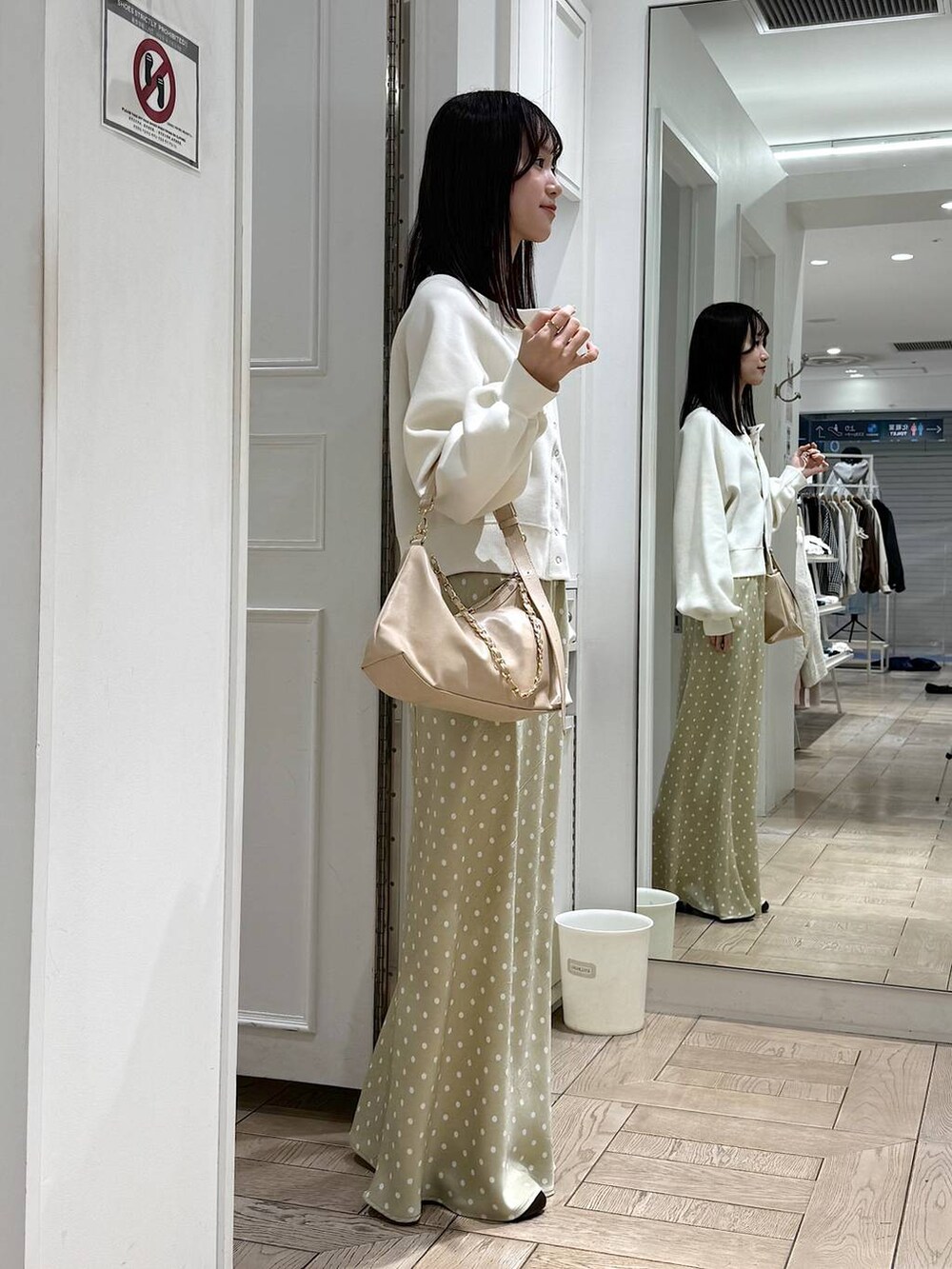 ベージュ系のスカート、ベージュ系のショルダーバッグ、ブラウン系のサンダルを着用したレディースの春コーディネートの2枚目の写真