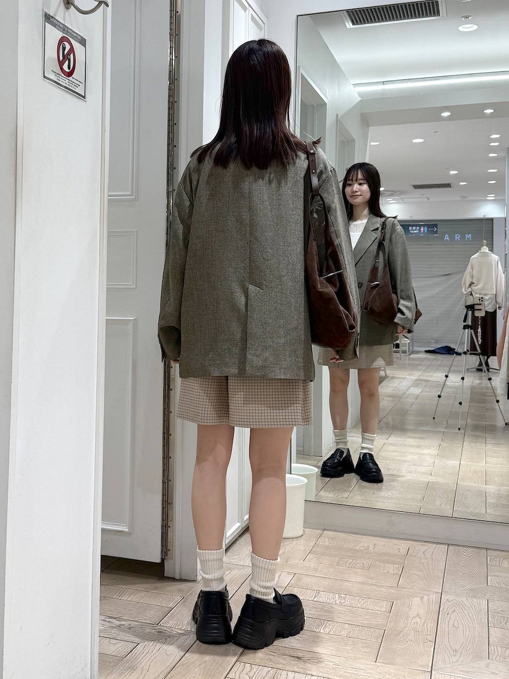 ブラウン系のテーラードジャケット、ブラック系のローファー、ブラウン系のショルダーバッグを着用したレディースの冬コーディネートの3枚目の写真