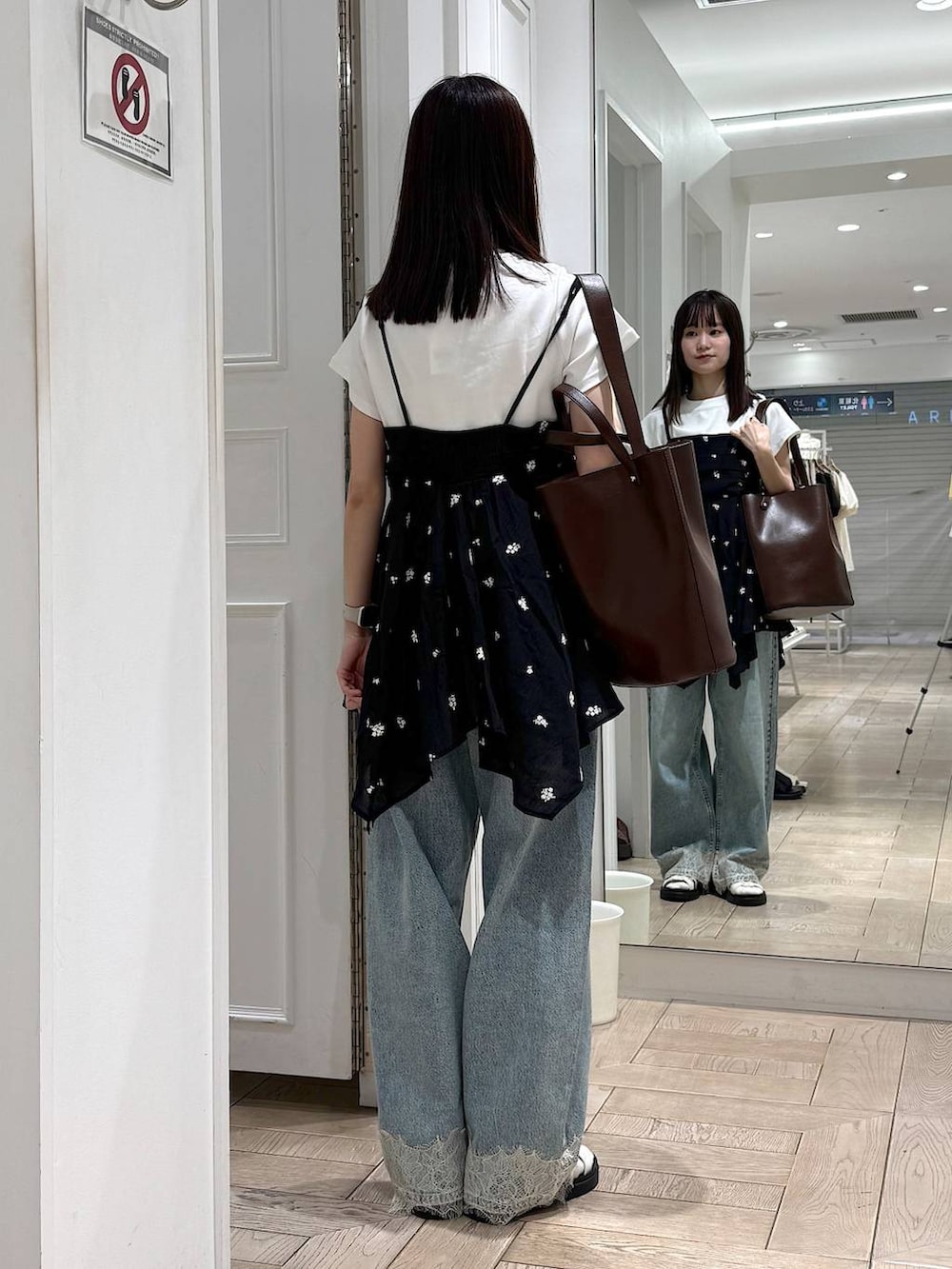 ブルー系のデニムパンツ、ホワイト系のTシャツ/カットソー、ホワイト系のサンダルを着用したレディースの夏コーディネートの3枚目の写真