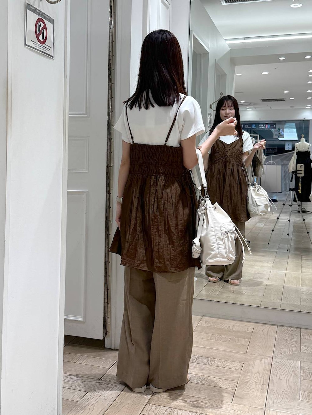 ブラウン系のワンピース、ホワイト系のTシャツ/カットソー、ベージュ系のスラックスを着用したレディースの夏コーディネートの3枚目の写真