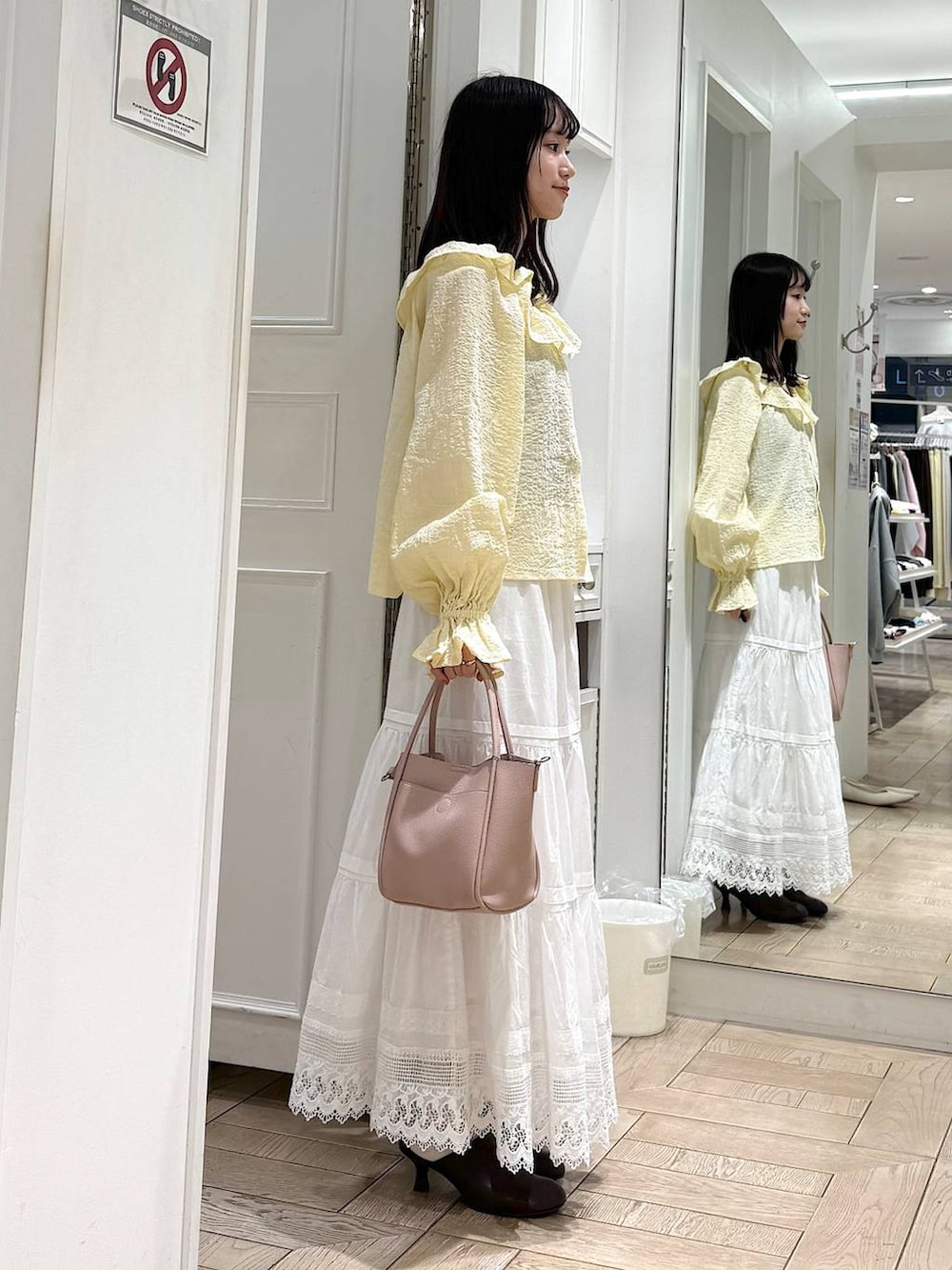 ピンク系のショルダーバッグ、ブラウン系のサンダル、イエロー系のシャツ/ブラウスを着用したレディースの春コーディネートの2枚目の写真