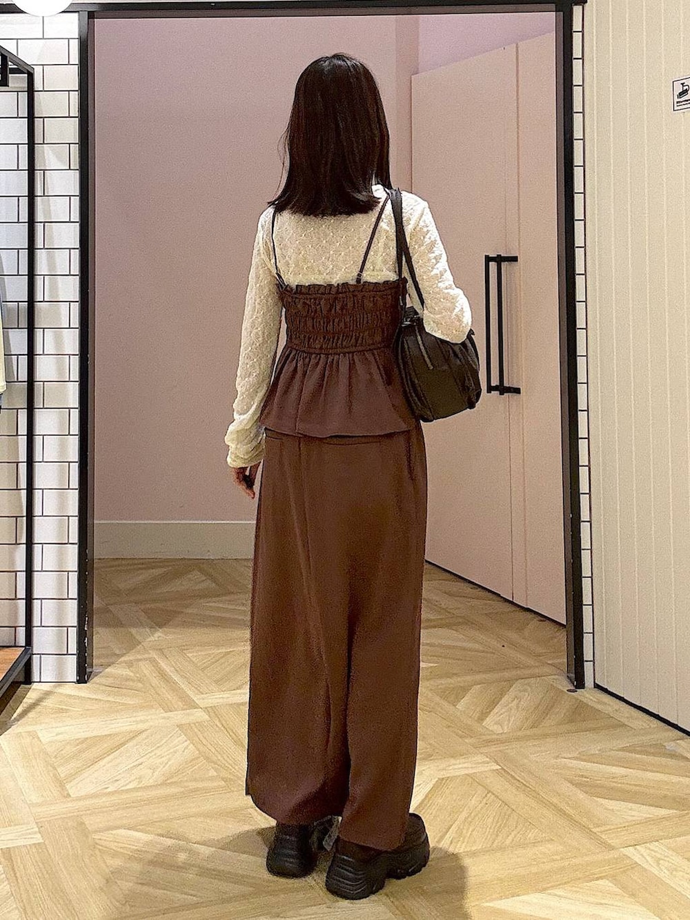 ブラウン系のボストンバッグ、ブラウン系のスカート、ホワイト系のTシャツ/カットソーを着用したレディースの夏コーディネートの3枚目の写真