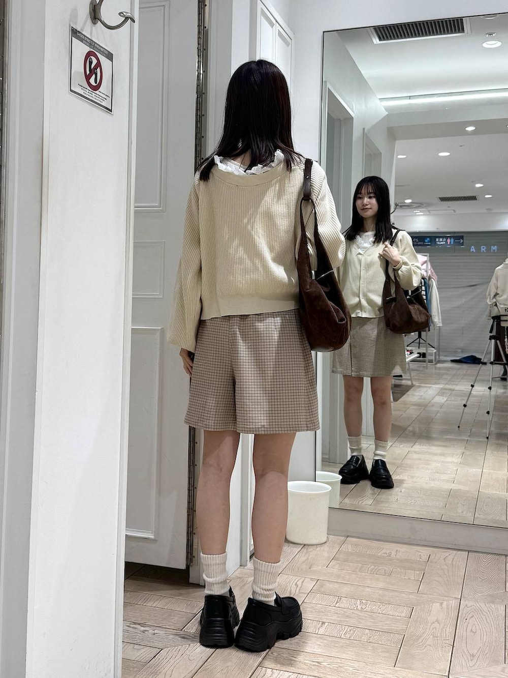 ブラック系のローファー、ブラウン系のショルダーバッグ、ベージュ系のカーディガン/ボレロを着用したレディースの冬コーディネートの3枚目の写真