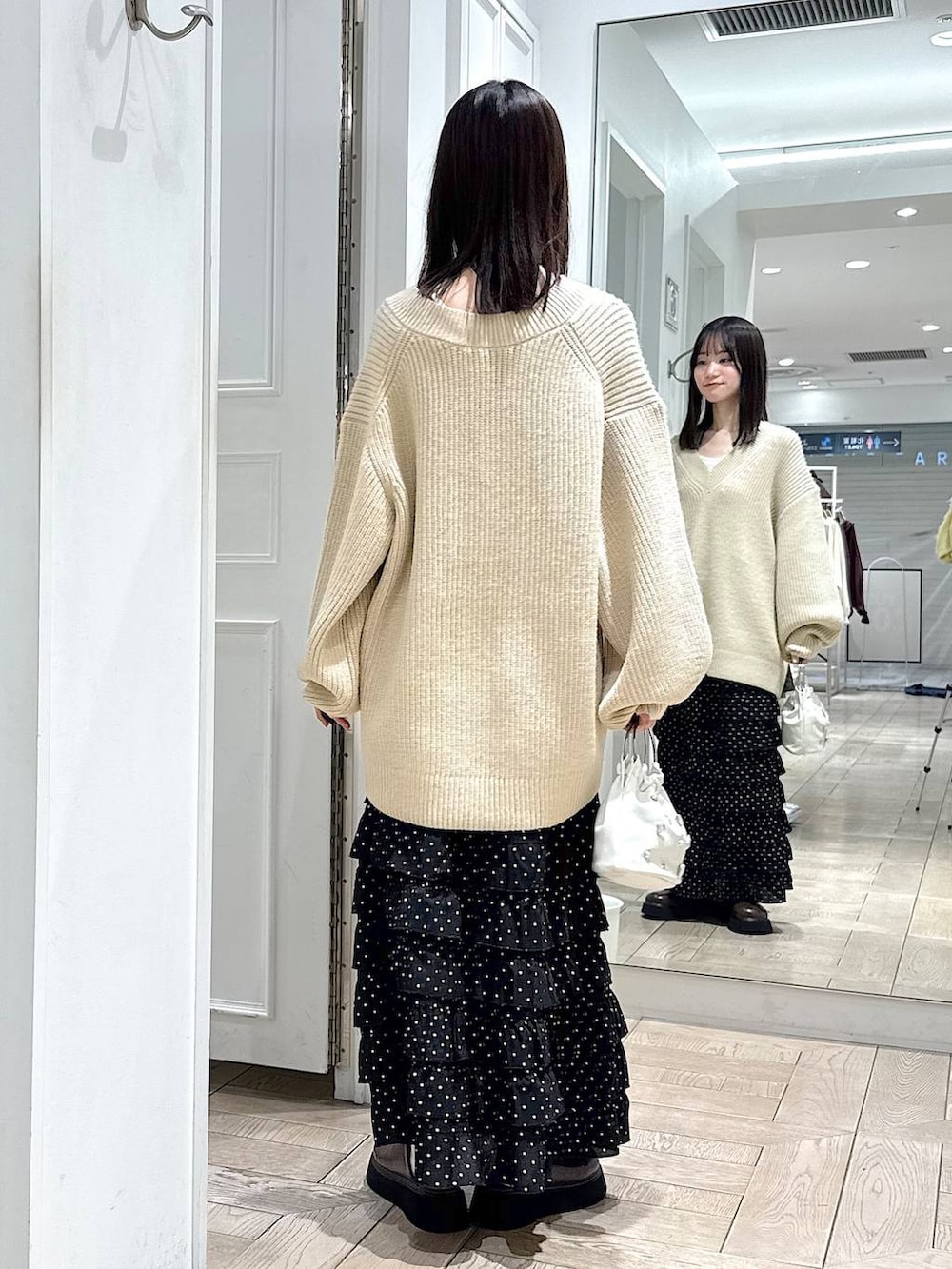 その他のスカート、ブラウン系のサンダル、ホワイト系のハンドバッグを着用したレディースの冬コーディネートの3枚目の写真