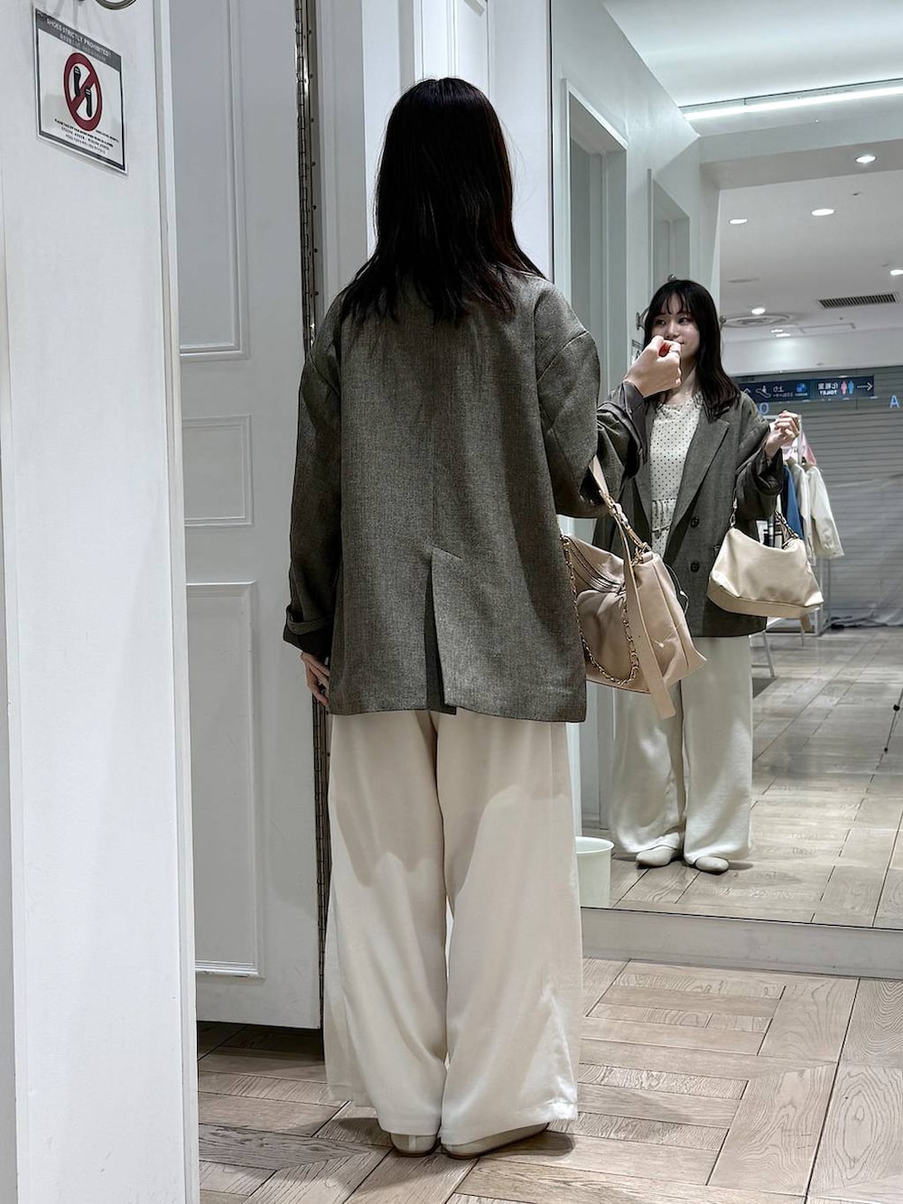 ブラウン系のテーラードジャケット、ベージュ系のショルダーバッグ、ホワイト系のパンプスを着用したレディースの春コーディネートの3枚目の写真