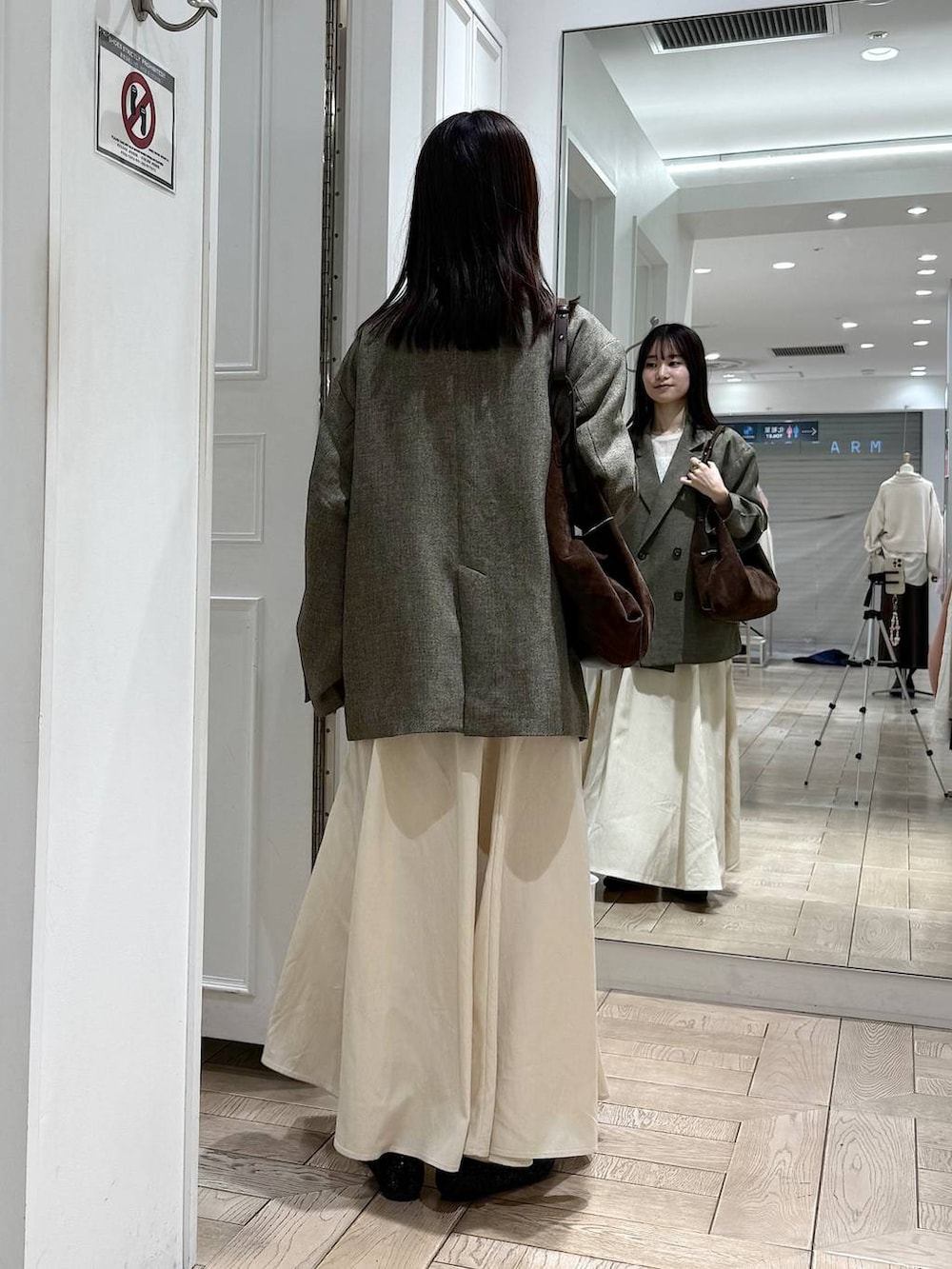 ブラウン系のテーラードジャケット、ブラック系のパンプス、ブラウン系のショルダーバッグを着用したレディースの冬コーディネートの3枚目の写真