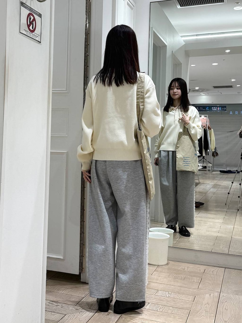 グレー系のスウェットパンツ、ホワイト系のニット/セーター、ベージュ系のトートバッグを着用したレディースの冬コーディネートの3枚目の写真