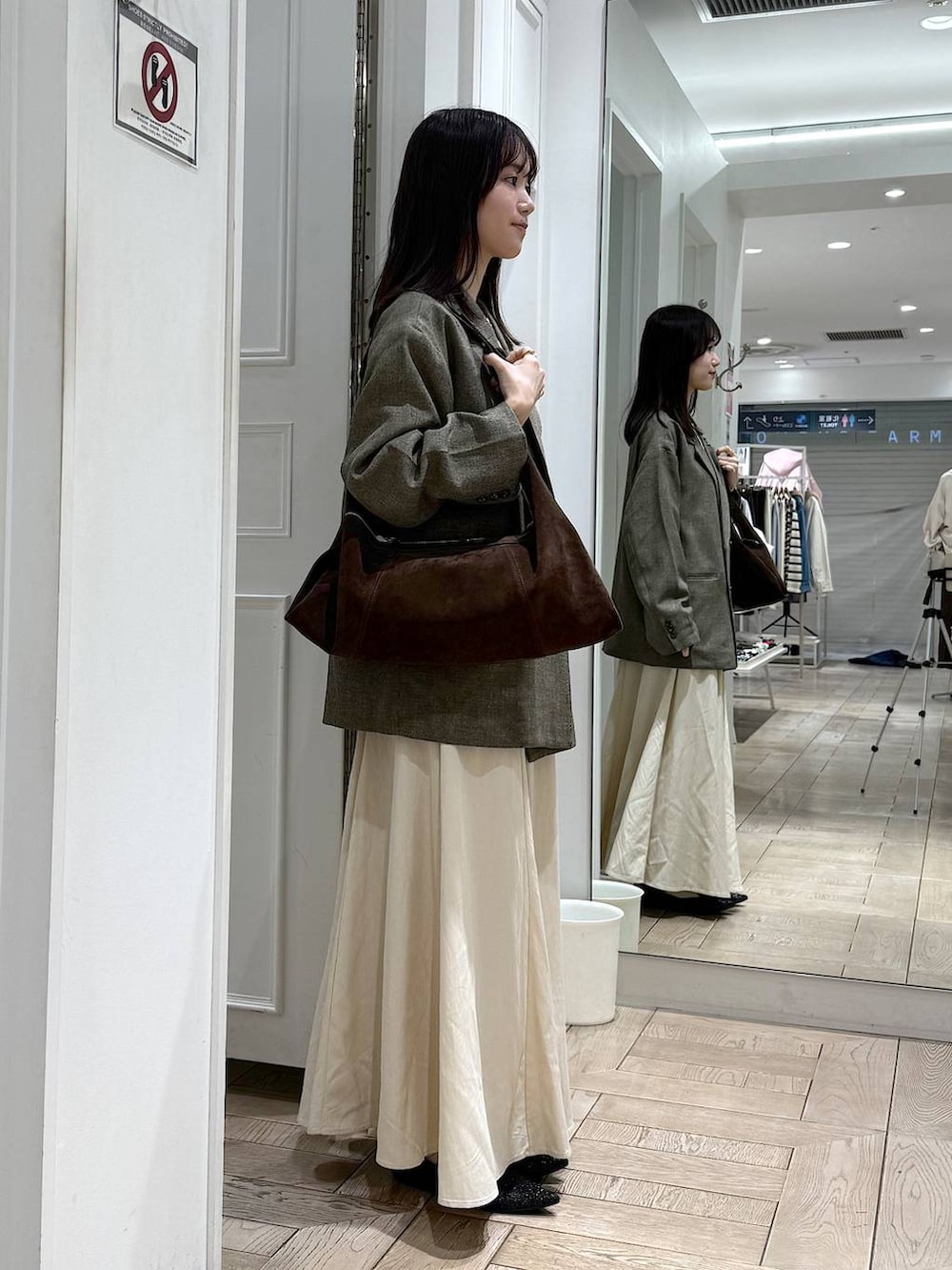 ブラウン系のテーラードジャケット、ブラック系のパンプス、ブラウン系のショルダーバッグを着用したレディースの冬コーディネートの2枚目の写真