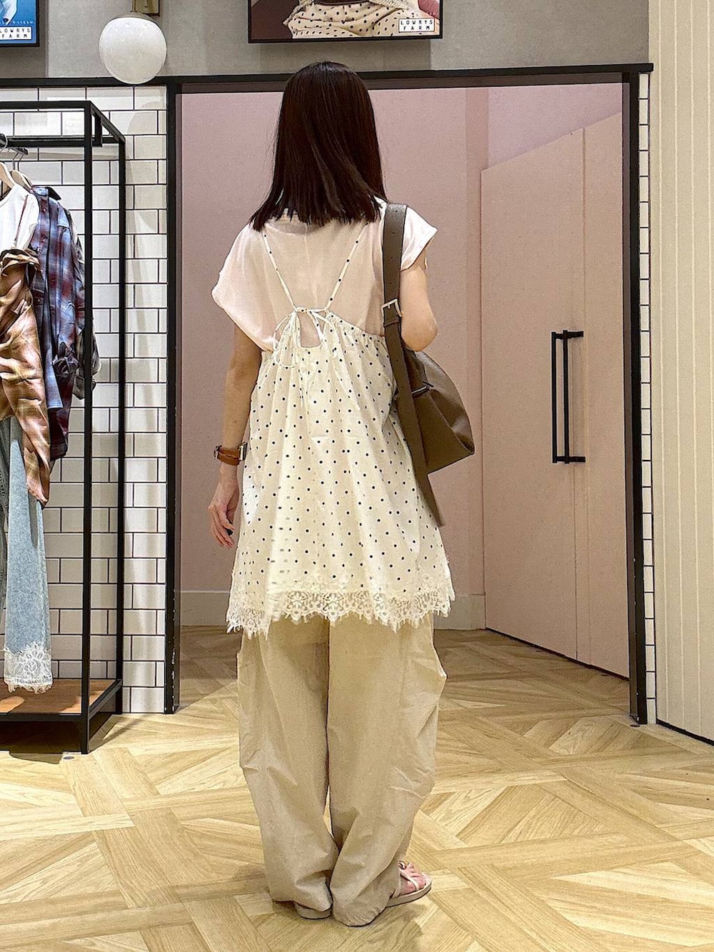 ピンク系のTシャツ/カットソー、ベージュ系のその他パンツ、ホワイト系のサンダルを着用したレディースの夏コーディネートの3枚目の写真