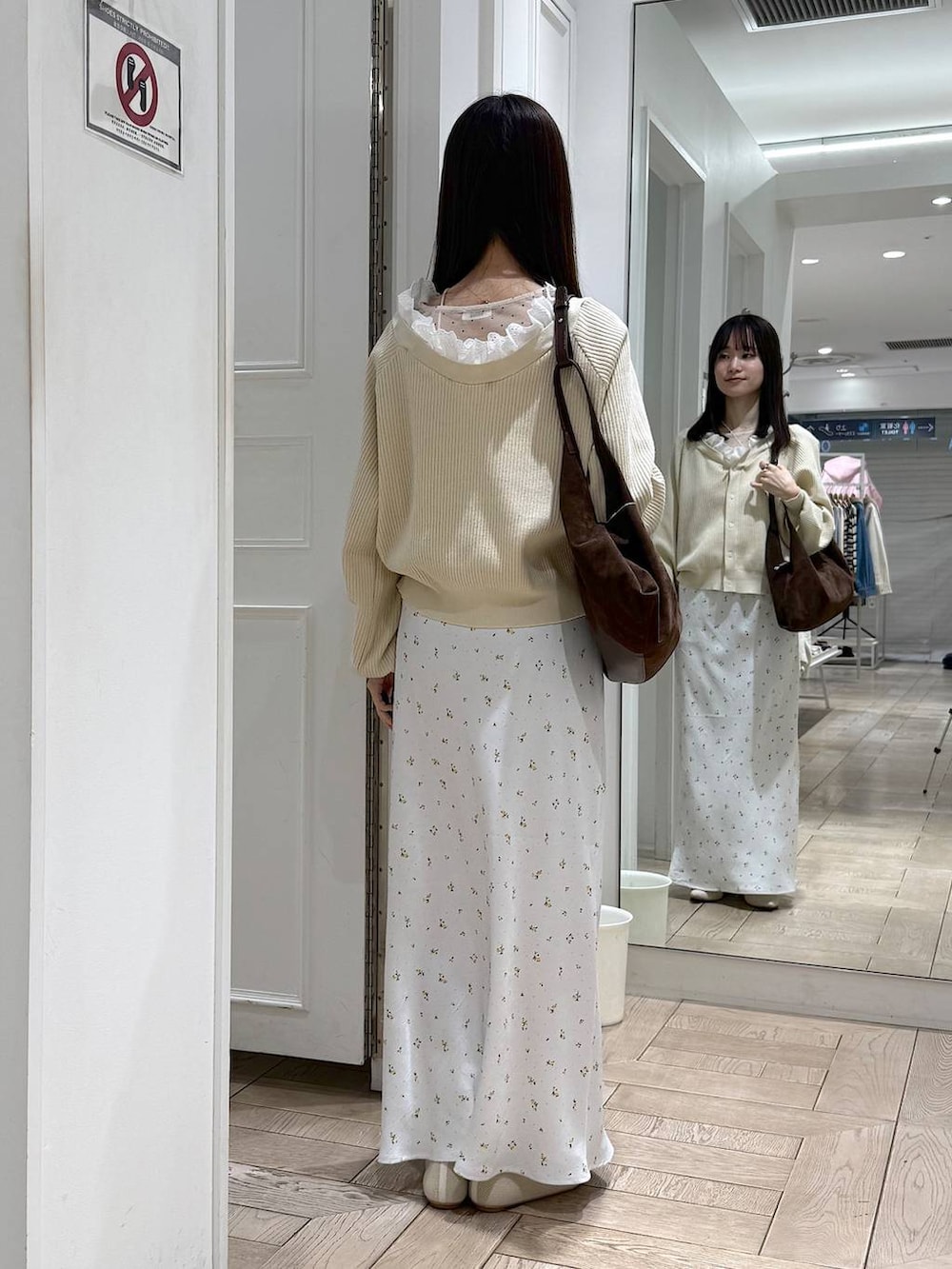 ホワイト系のスカート、ホワイト系のパンプス、ブラウン系のショルダーバッグを着用したレディースの冬コーディネートの3枚目の写真