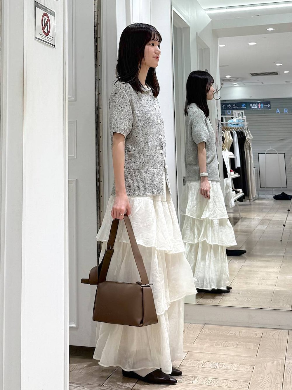 ブラウン系のサンダル、ブラウン系のショルダーバッグ、グレー系のTシャツ/カットソーを着用したレディースの春コーディネートの2枚目の写真