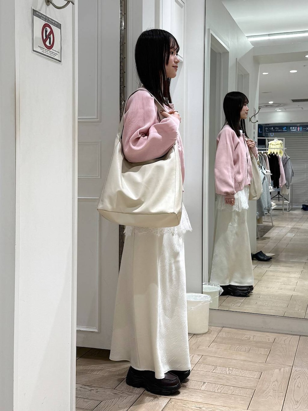 ホワイト系のスカート、ホワイト系のショルダーバッグ、ブラウン系のローファーを着用したレディースの春コーディネートの2枚目の写真