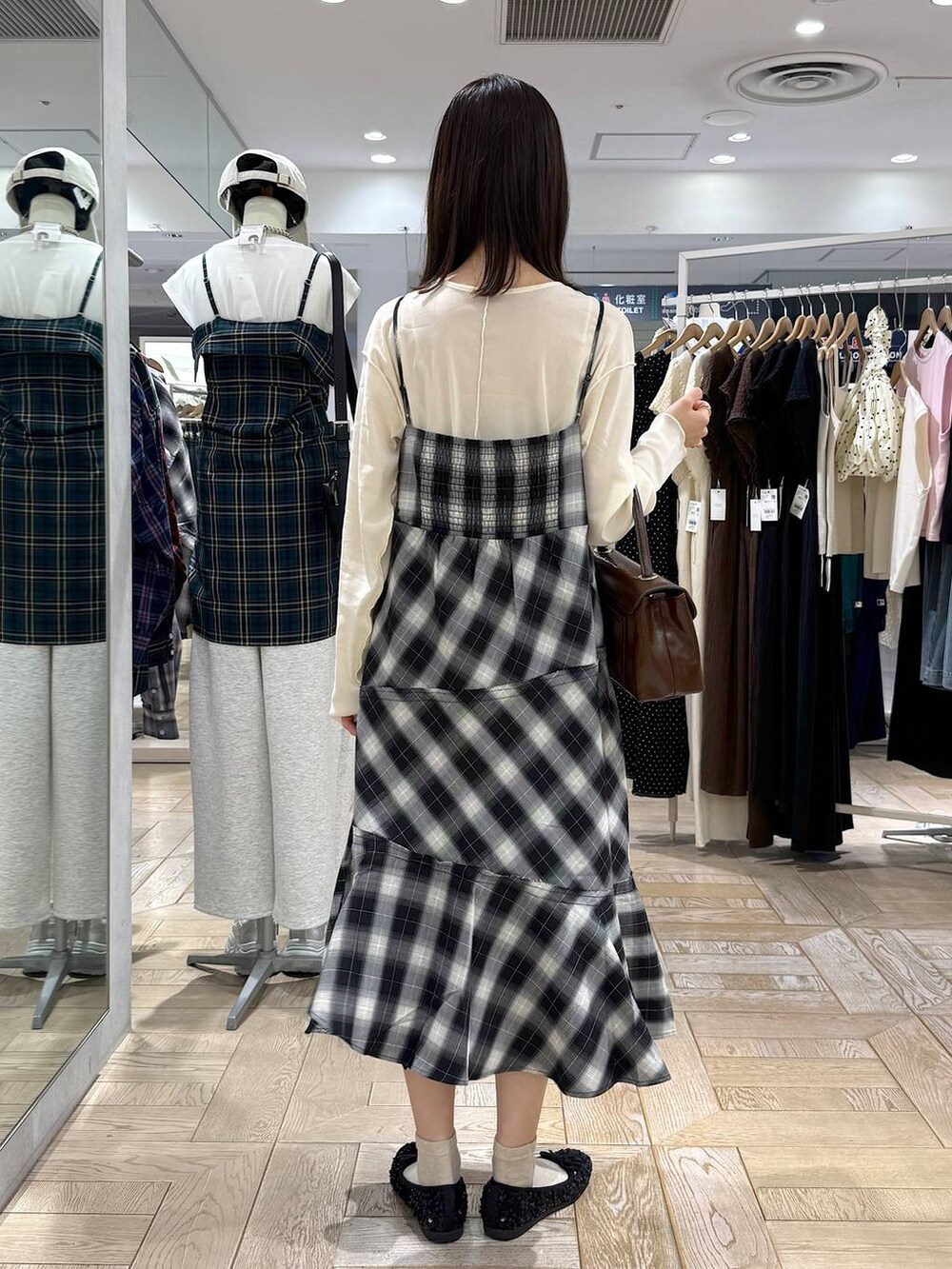 ブラウン系のボストンバッグ、ホワイト系のTシャツ/カットソー、グレー系のワンピースを着用したレディースの秋コーディネートの3枚目の写真