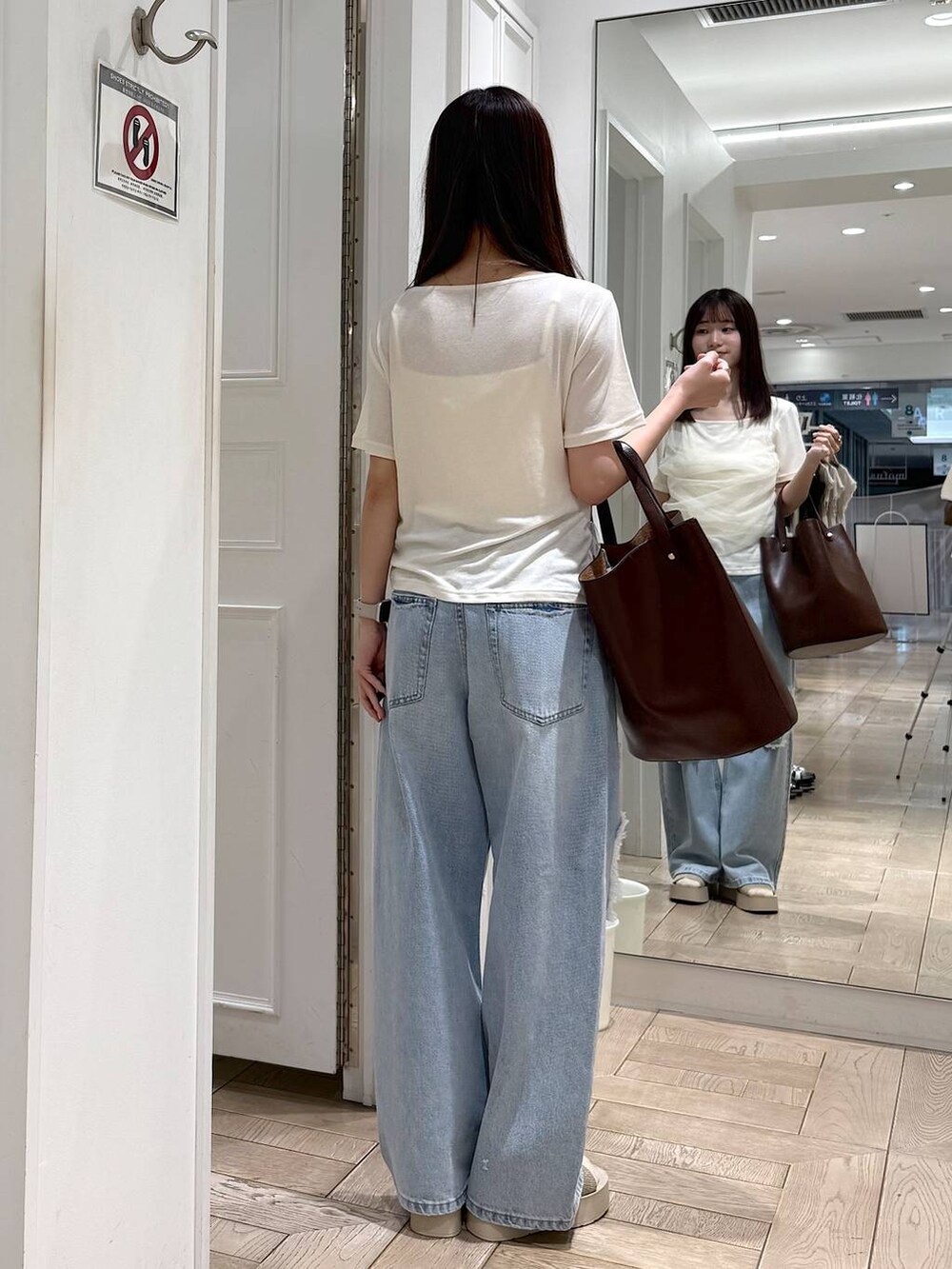 ホワイト系のTシャツ/カットソー、ブルー系のデニムパンツ、ホワイト系のサンダルを着用したレディースの夏コーディネートの3枚目の写真