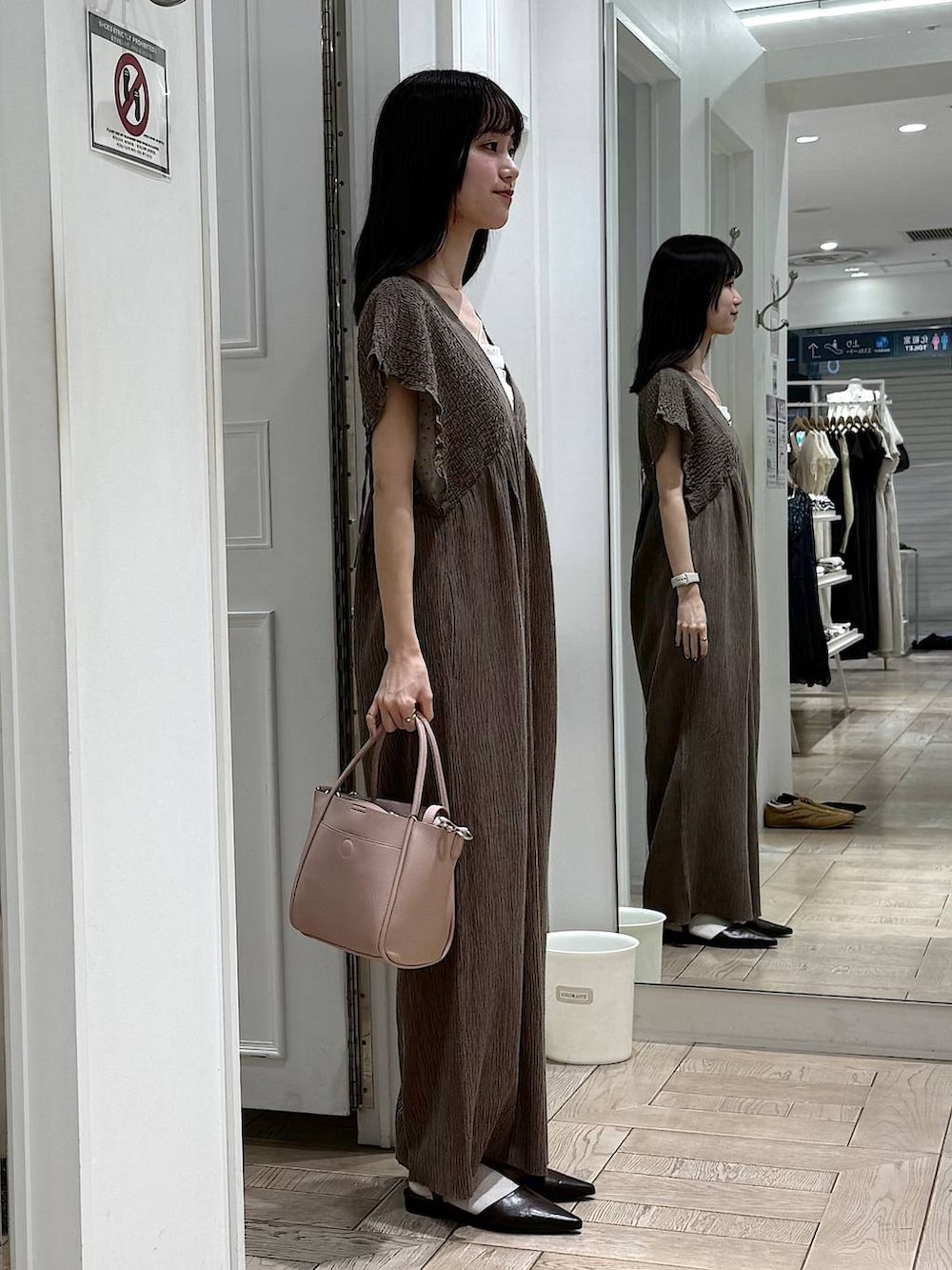 ピンク系のショルダーバッグ、ブラウン系のサンダルを着用したレディースの春コーディネートの2枚目の写真