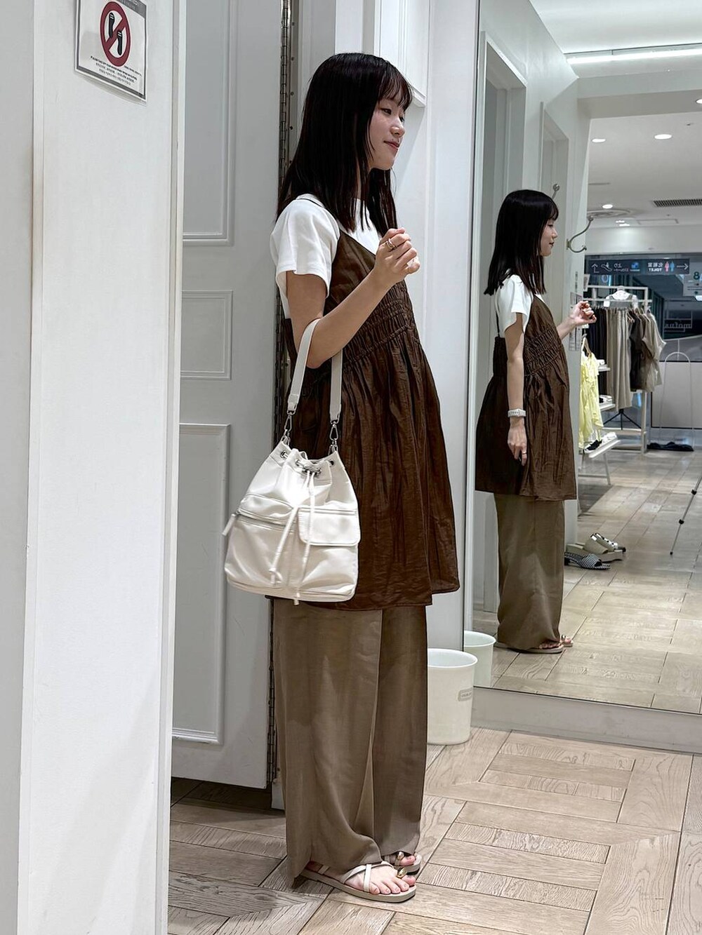 ブラウン系のワンピース、ホワイト系のTシャツ/カットソー、ベージュ系のスラックスを着用したレディースの夏コーディネートの2枚目の写真