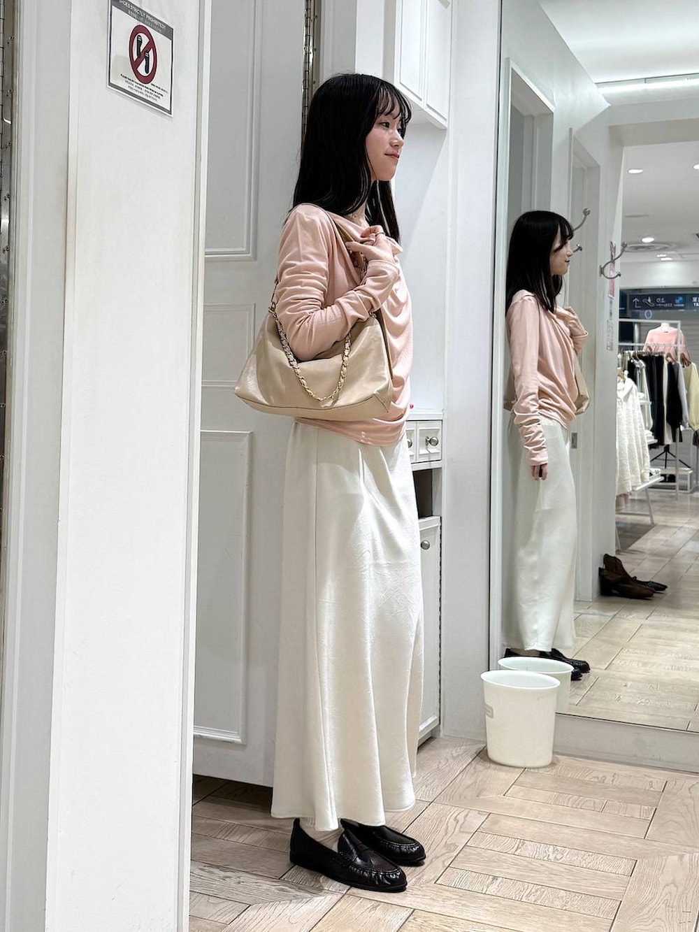 ホワイト系のスカート、ベージュ系のショルダーバッグ、ブラウン系のローファーを着用したレディースの冬コーディネートの2枚目の写真