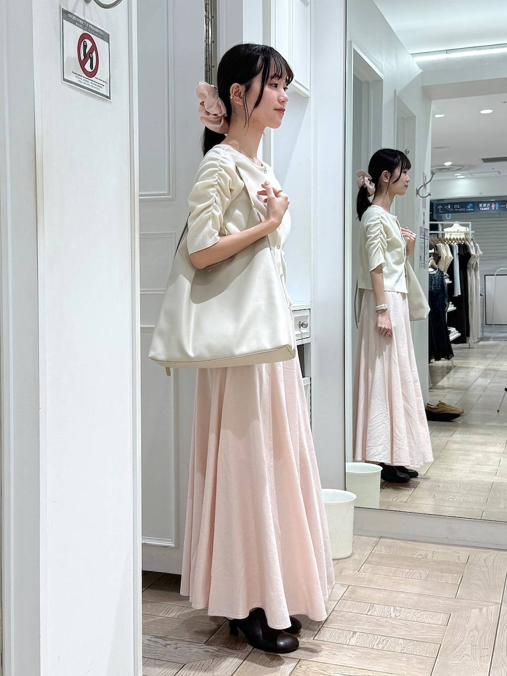 ホワイト系のショルダーバッグ、ブラウン系のサンダル、ホワイト系のTシャツ/カットソーを着用したレディースの春コーディネートの2枚目の写真