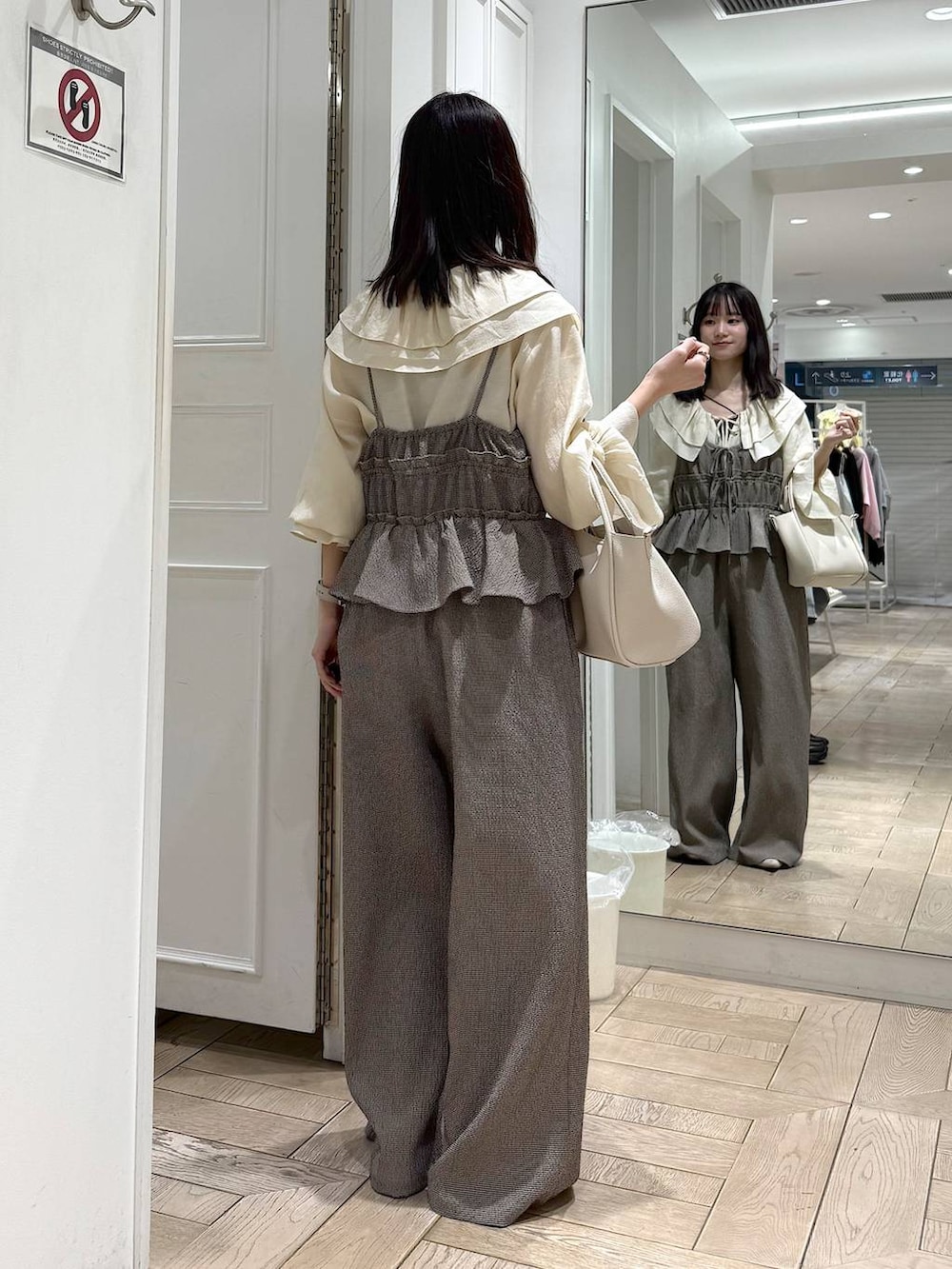 ホワイト系のショルダーバッグ、ホワイト系のパンプス、ホワイト系のシャツ/ブラウスを着用したレディースの春コーディネートの3枚目の写真