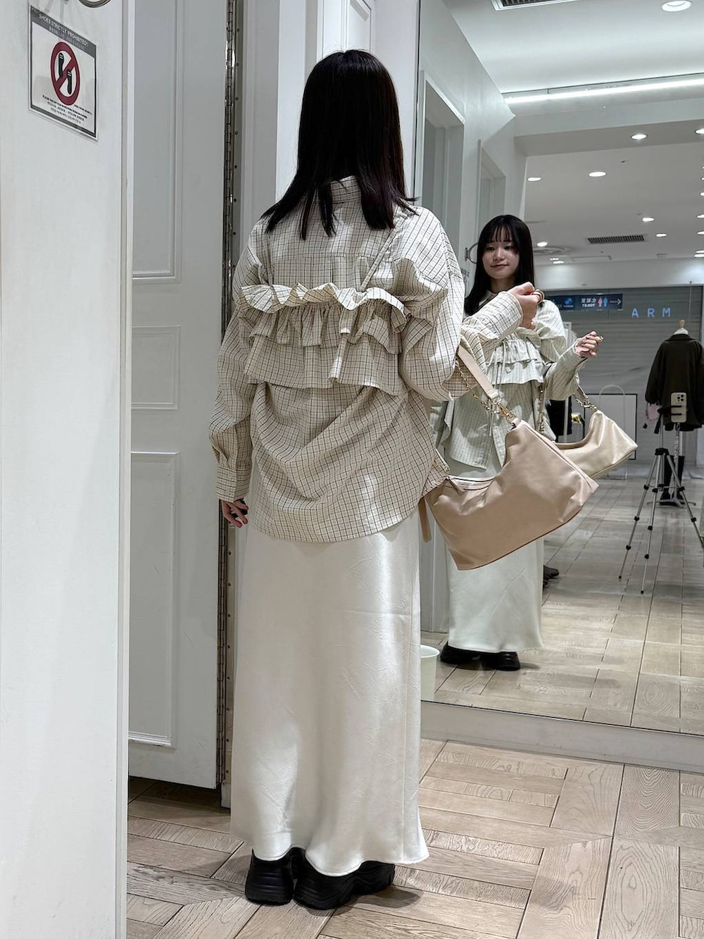 ホワイト系のスカート、ベージュ系のショルダーバッグ、ブラウン系のローファーを着用したレディースの冬コーディネートの3枚目の写真