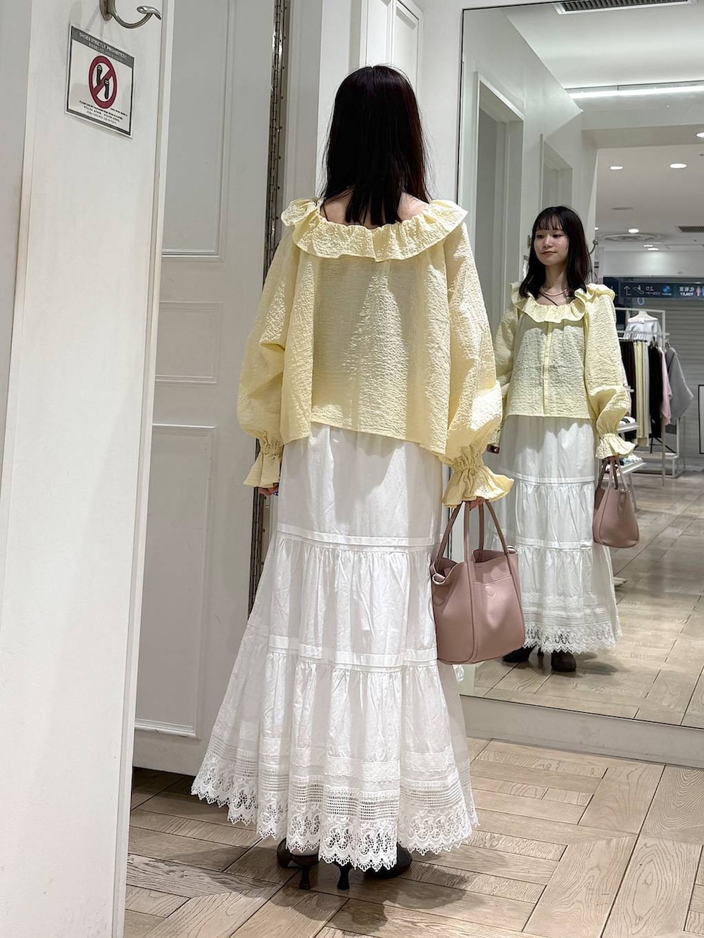 ピンク系のショルダーバッグ、ブラウン系のサンダル、イエロー系のシャツ/ブラウスを着用したレディースの春コーディネートの3枚目の写真