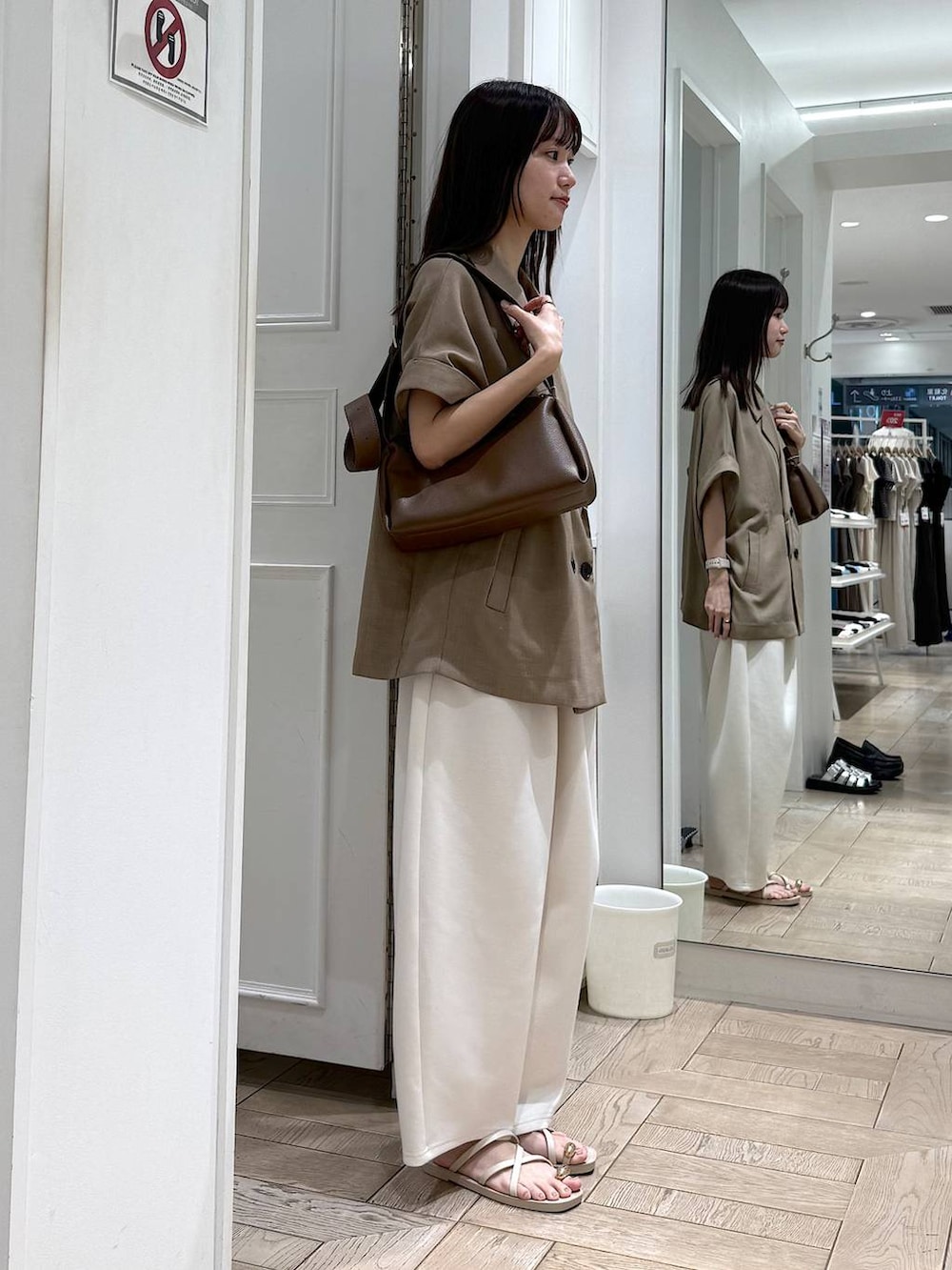 ベージュ系のスウェットパンツ、ベージュ系のテーラードジャケット、ホワイト系のサンダルを着用したレディースの夏コーディネートの2枚目の写真