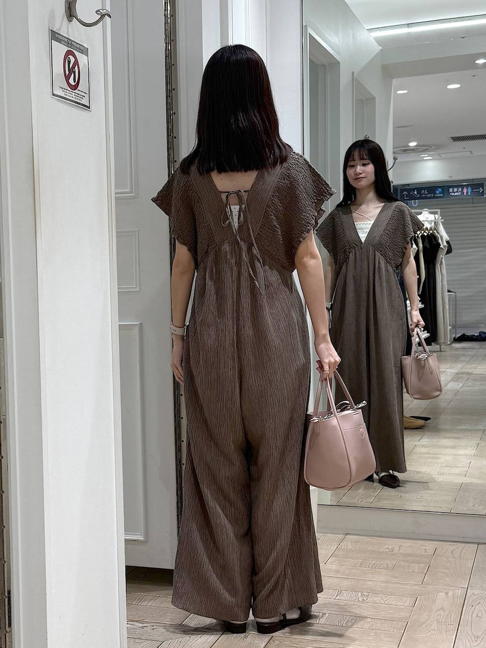 ピンク系のショルダーバッグ、ブラウン系のサンダルを着用したレディースの春コーディネートの3枚目の写真