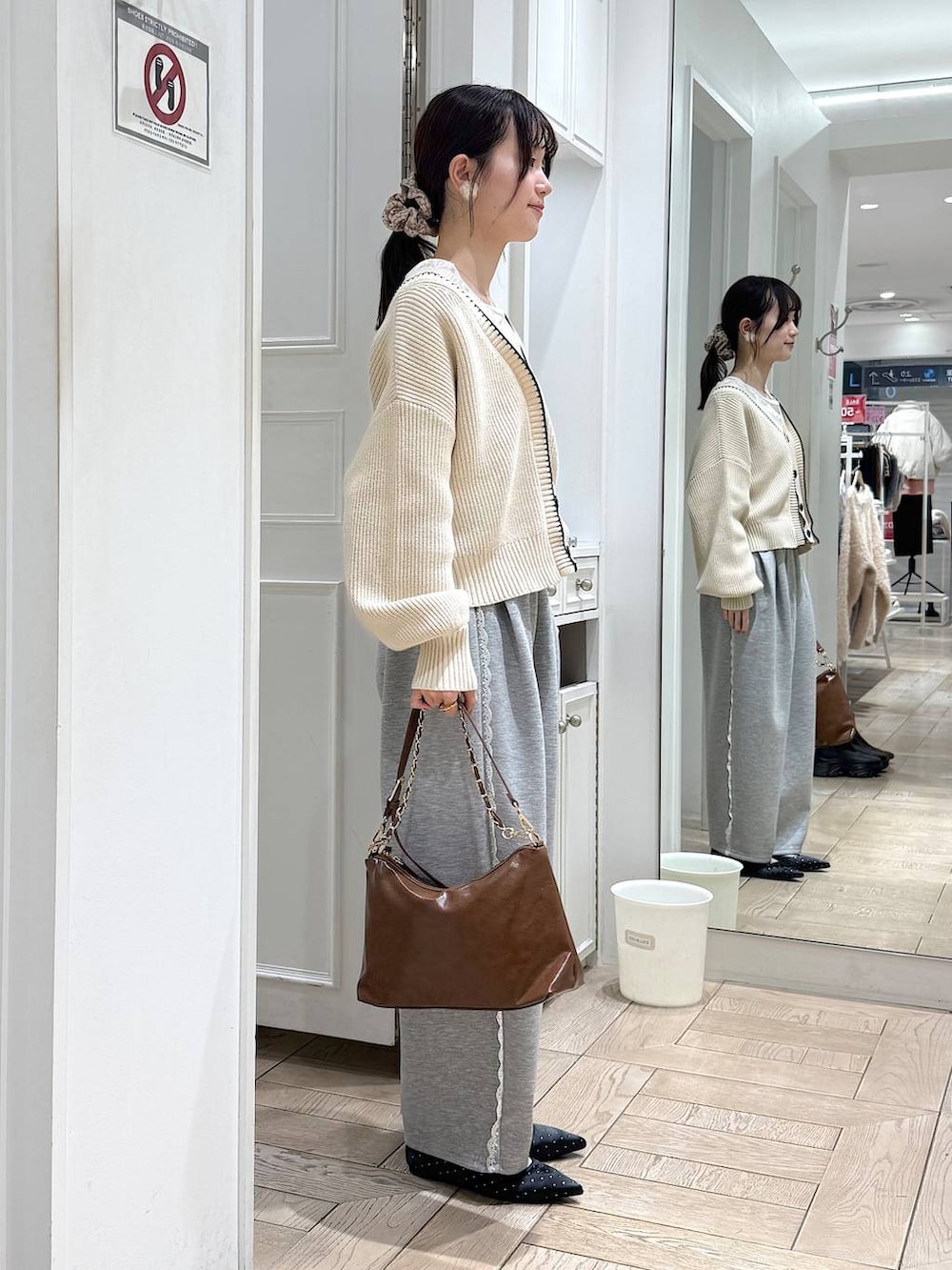 グレー系のスウェットパンツ、ホワイト系のカーディガン/ボレロ、ブラック系のパンプスを着用したレディースの冬コーディネートの2枚目の写真