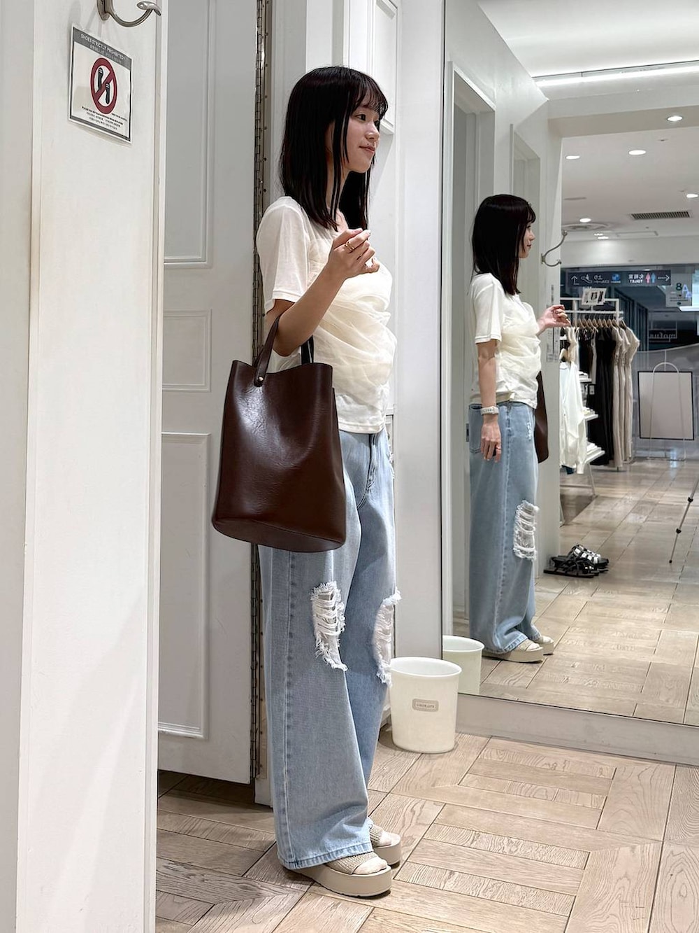 ホワイト系のTシャツ/カットソー、ブルー系のデニムパンツ、ホワイト系のサンダルを着用したレディースの夏コーディネートの2枚目の写真