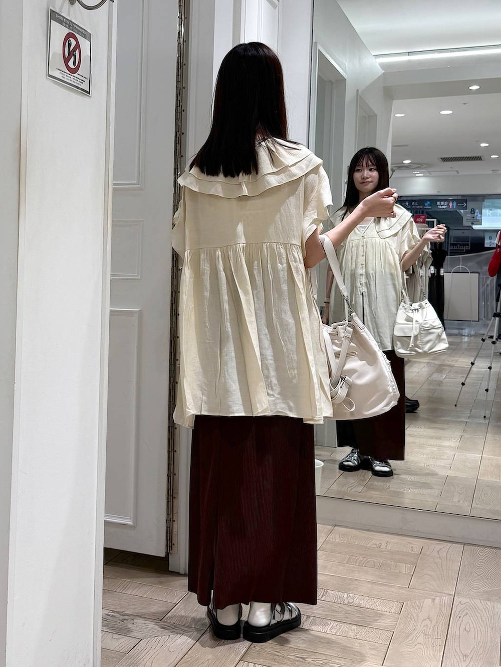 ブラウン系のスカート、シルバー系のサンダル、ホワイト系のショルダーバッグを着用したレディースの夏コーディネートの3枚目の写真