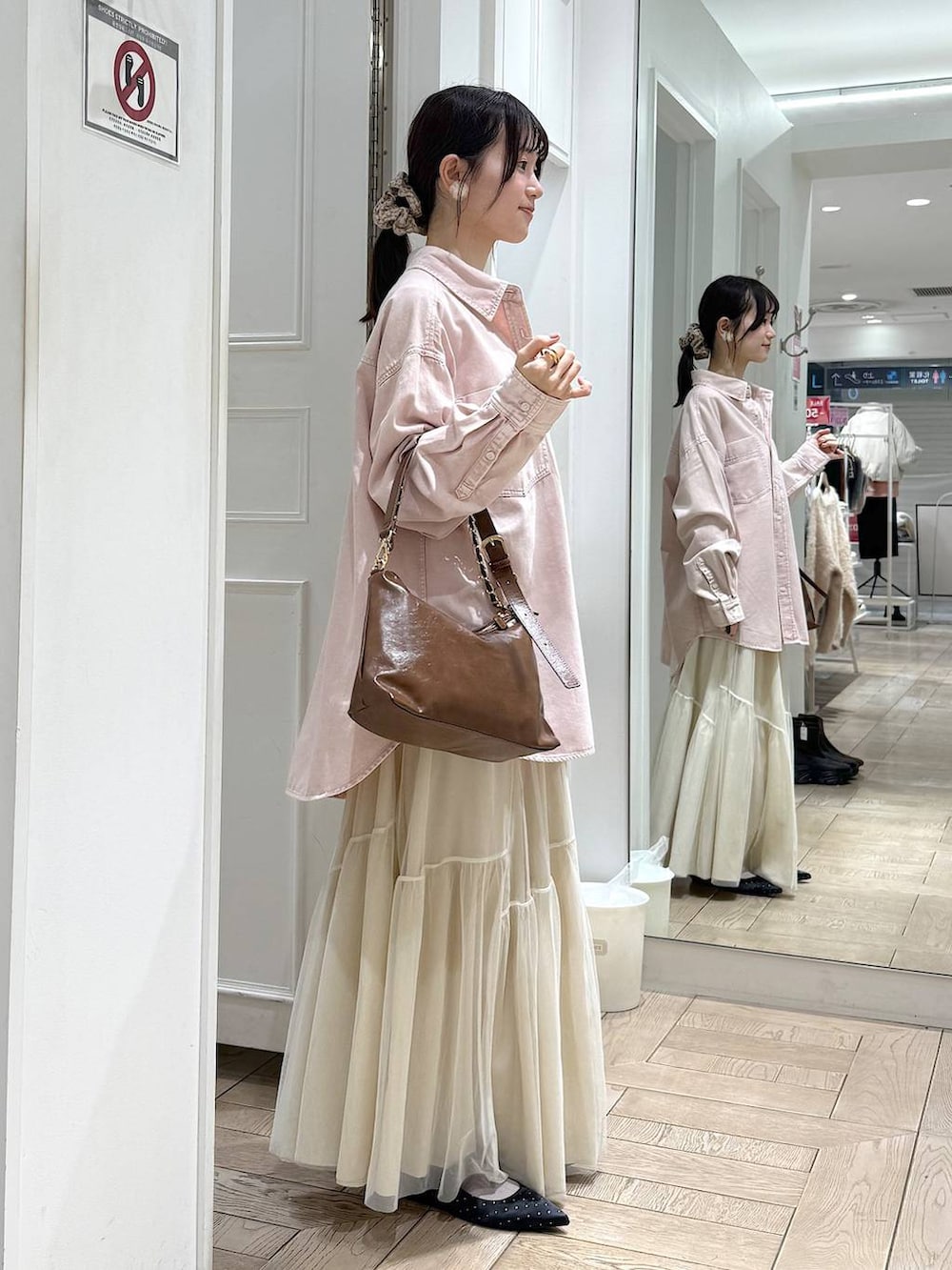 ブラック系のパンプス、ピンク系のシャツ/ブラウス、ブラウン系のショルダーバッグを着用したレディースの冬コーディネートの2枚目の写真