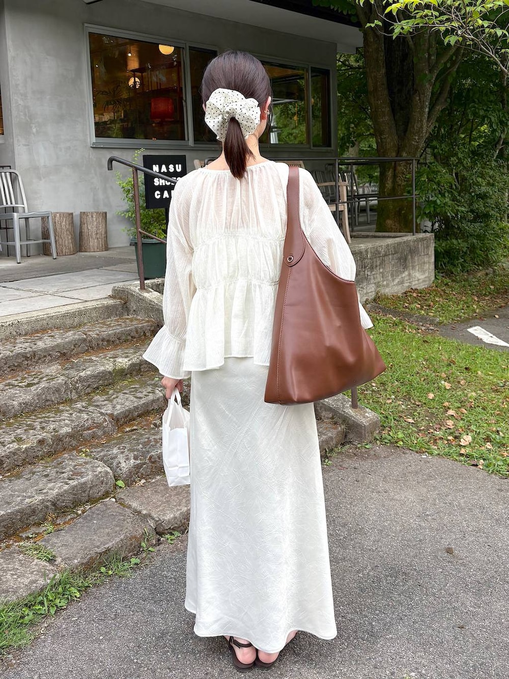 ブラウン系のサンダル、ホワイト系のシャツ/ブラウス、ホワイト系のスカートを着用したレディースの秋コーディネートの3枚目の写真