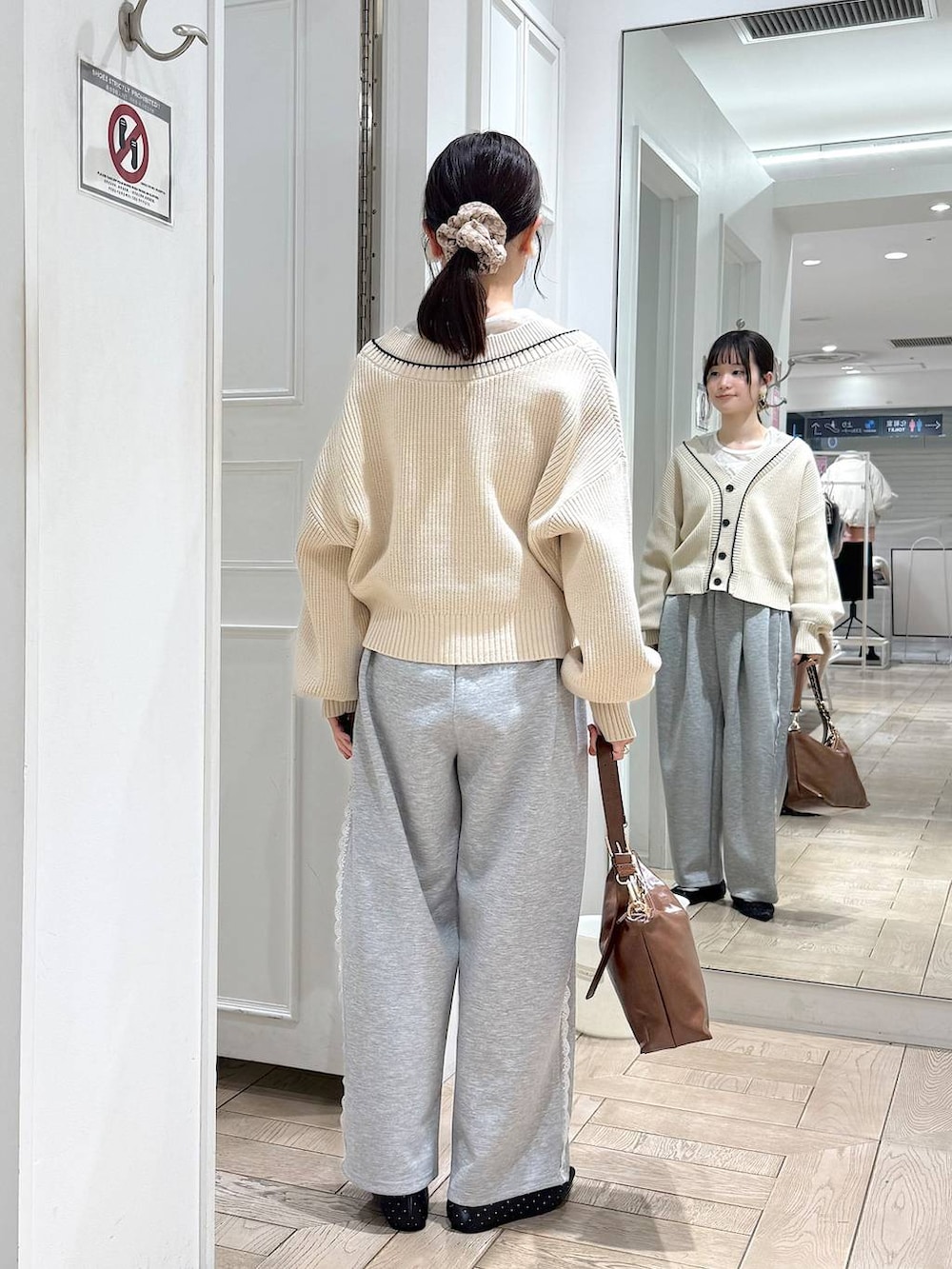 グレー系のスウェットパンツ、ホワイト系のカーディガン/ボレロ、ブラック系のパンプスを着用したレディースの冬コーディネートの3枚目の写真