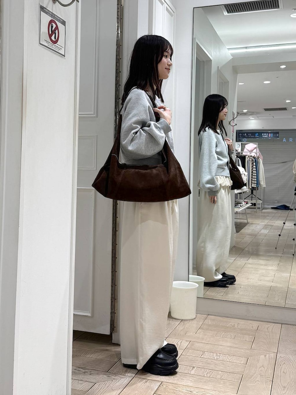 ブラック系のローファー、ホワイト系のその他パンツ、ブラウン系のショルダーバッグを着用したレディースの冬コーディネートの2枚目の写真