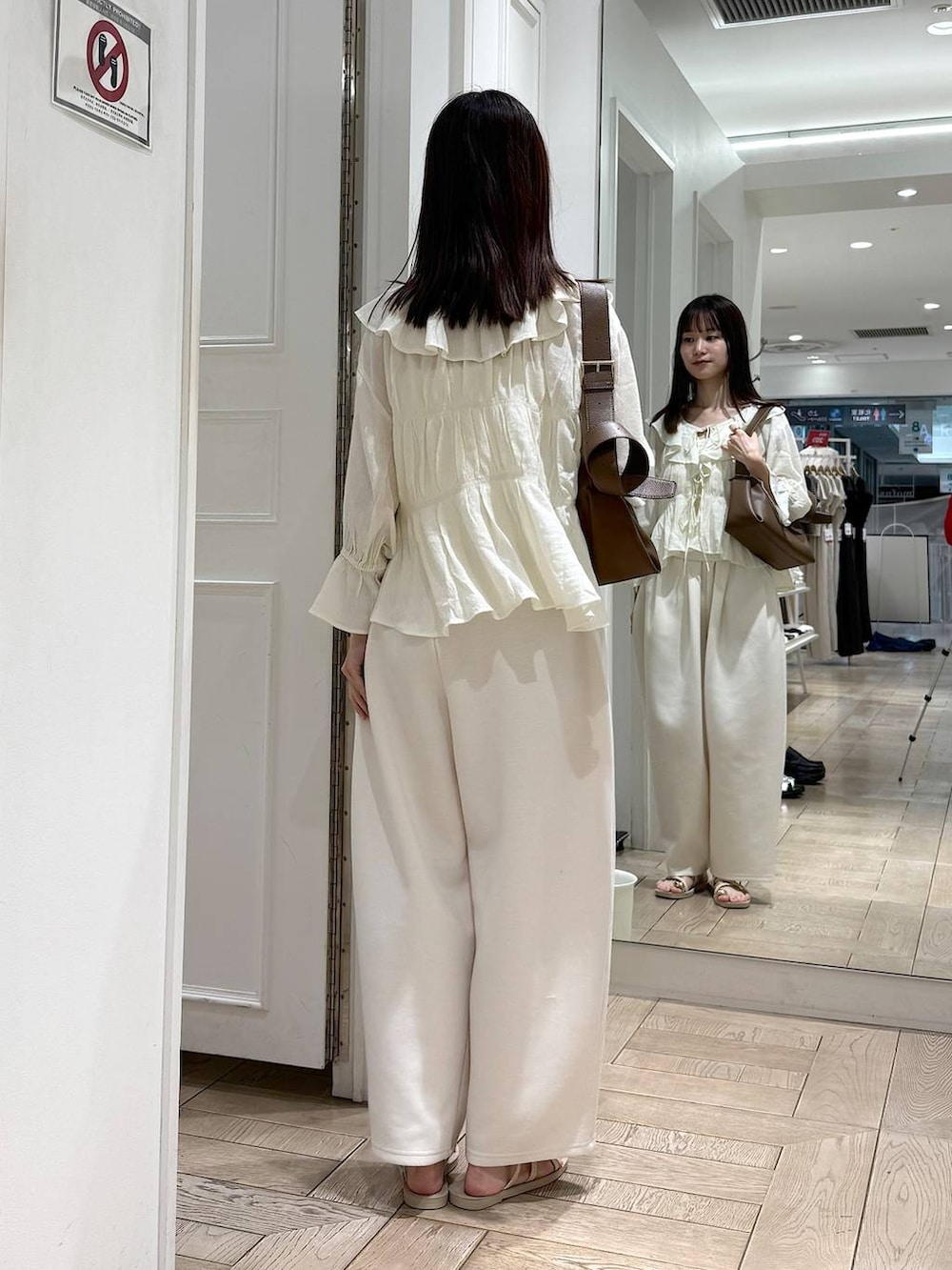 ベージュ系のスウェットパンツ、ホワイト系のサンダル、ホワイト系のシャツ/ブラウスを着用したレディースの夏コーディネートの3枚目の写真