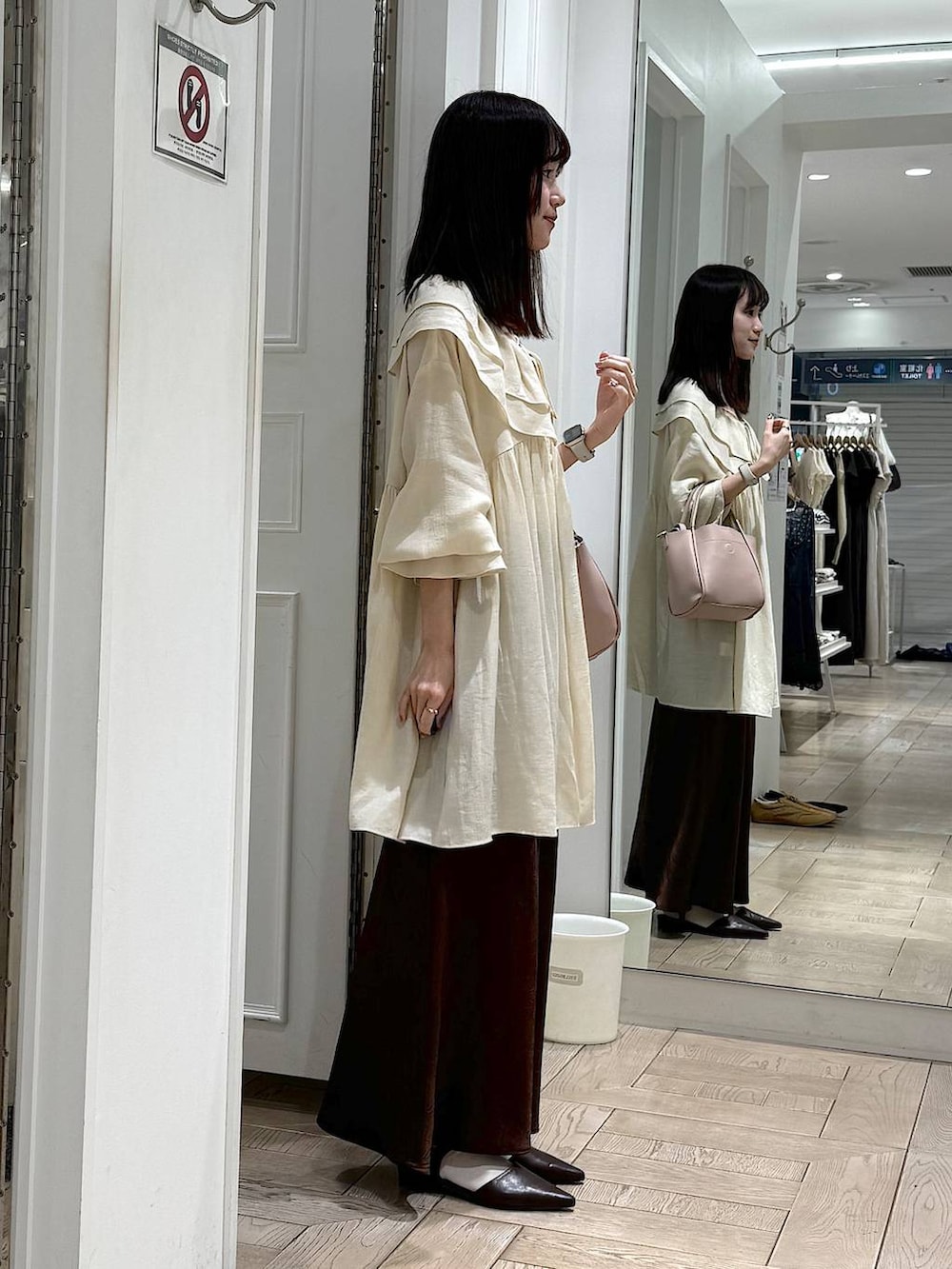 ブラウン系のスカート、ピンク系のショルダーバッグ、ホワイト系のシャツ/ブラウスを着用したレディースの春コーディネートの2枚目の写真