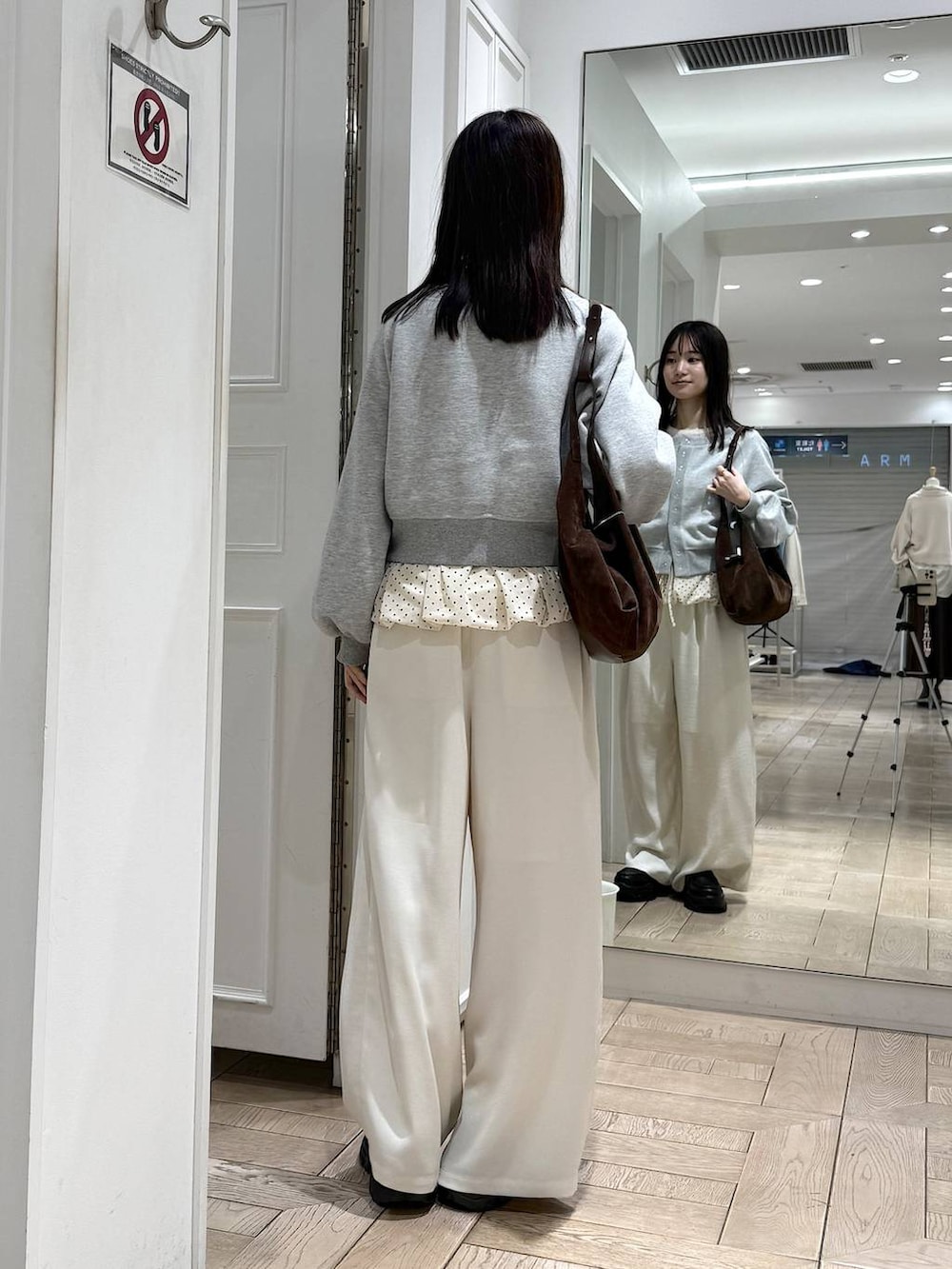 ブラック系のローファー、ホワイト系のその他パンツ、ブラウン系のショルダーバッグを着用したレディースの冬コーディネートの3枚目の写真