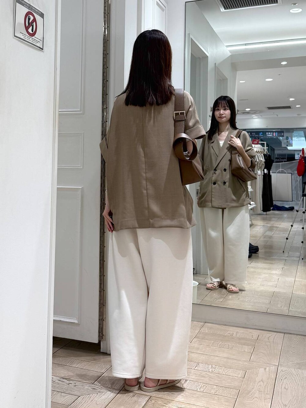 ベージュ系のスウェットパンツ、ベージュ系のテーラードジャケット、ホワイト系のサンダルを着用したレディースの夏コーディネートの3枚目の写真