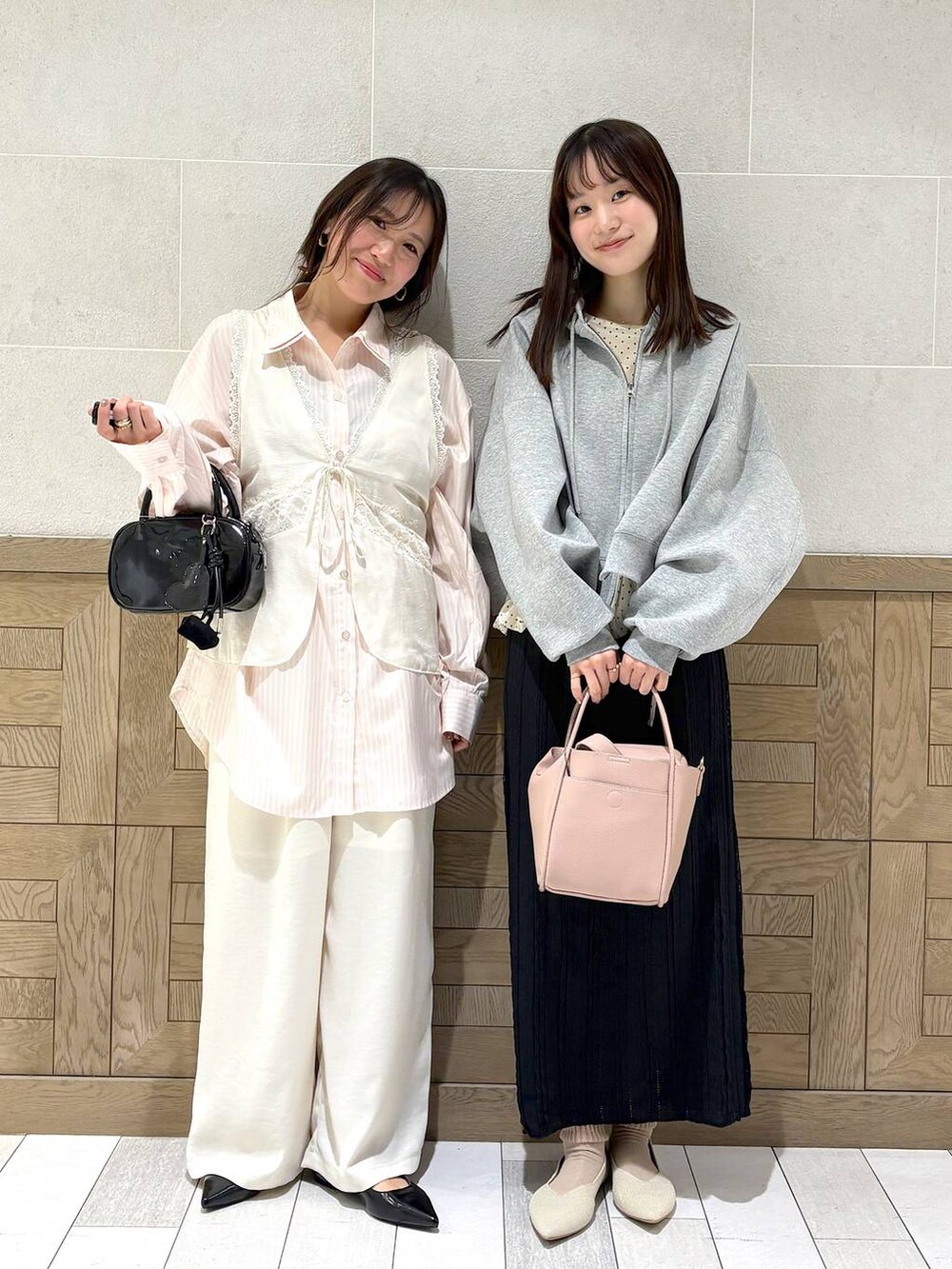 ピンク系のショルダーバッグ、グレー系のパーカー、ブラック系のボストンバッグを着用したレディースの春コーディネートの2枚目の写真