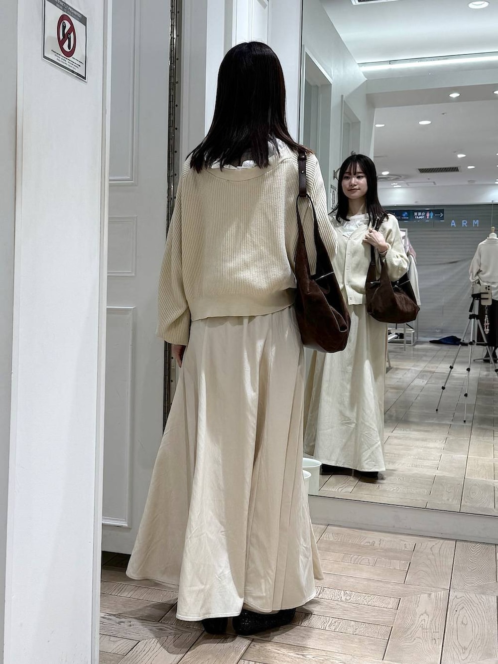 ブラック系のパンプス、ブラウン系のショルダーバッグ、ベージュ系のカーディガン/ボレロを着用したレディースの冬コーディネートの3枚目の写真