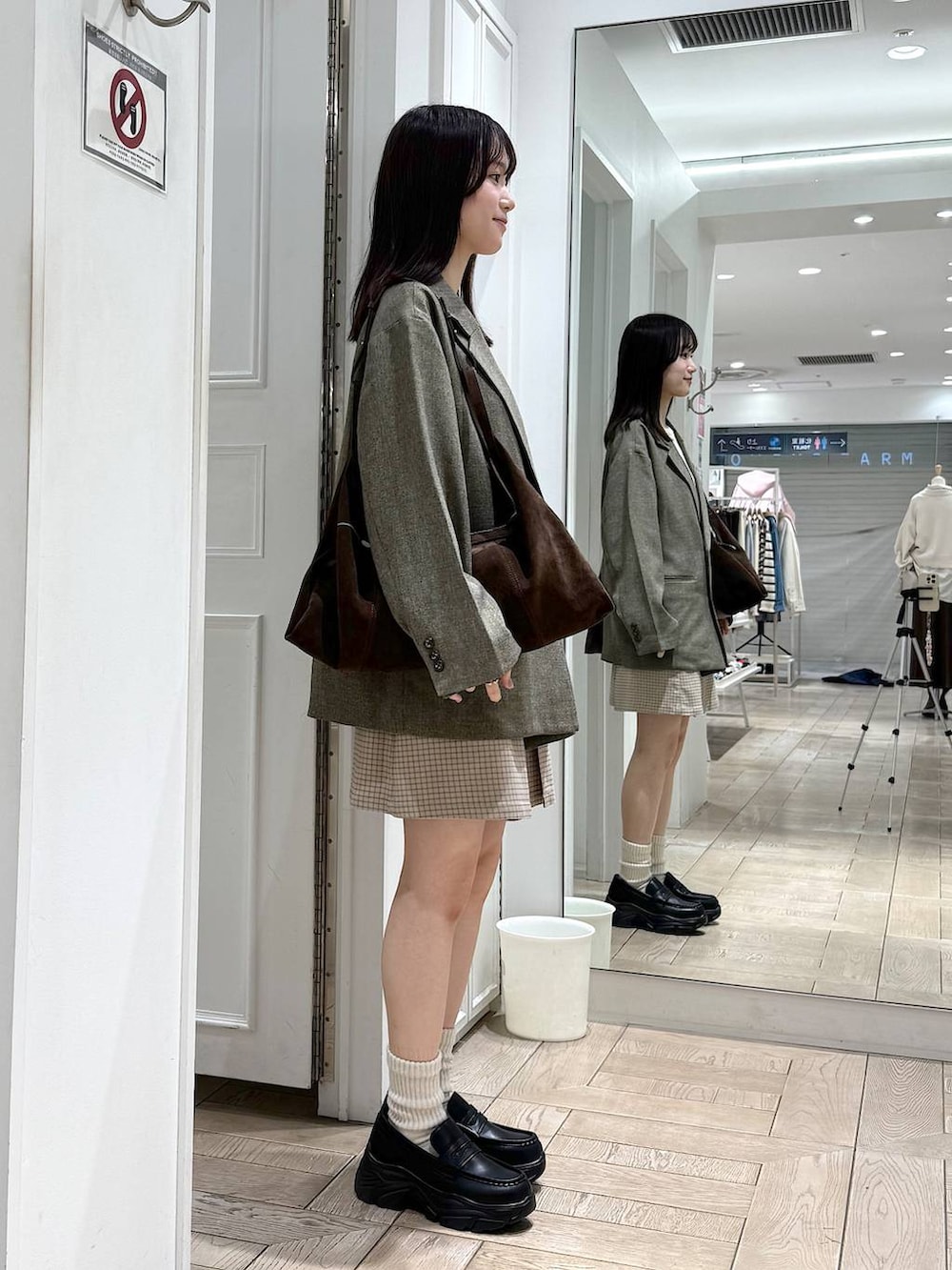 ブラウン系のテーラードジャケット、ブラック系のローファー、ブラウン系のショルダーバッグを着用したレディースの冬コーディネートの2枚目の写真