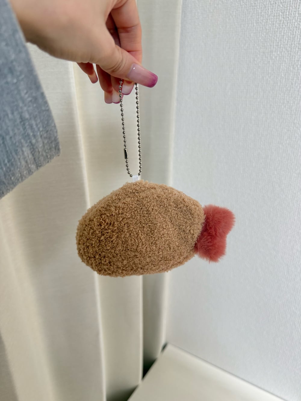 グレー系のトートバッグ、レッド系のハンドケア/ハンドクリーム、ブルー系のポーチを着用したレディースの冬コーディネートの4枚目の写真