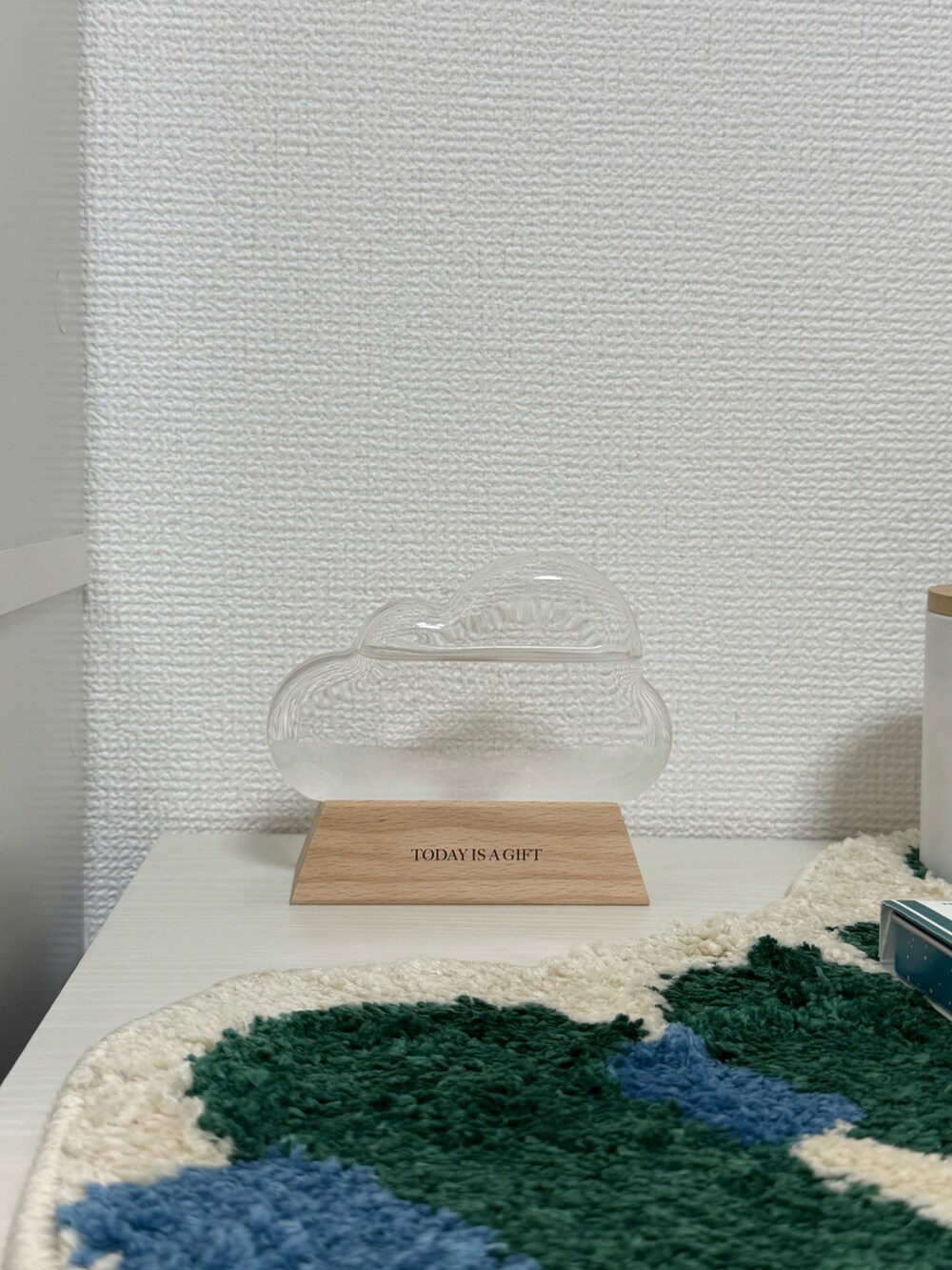 ホワイト系の掛け時計、グリーン系のラグ/マット、ベージュ系のフォトフレームを着用したレディースの秋コーディネートの4枚目の写真