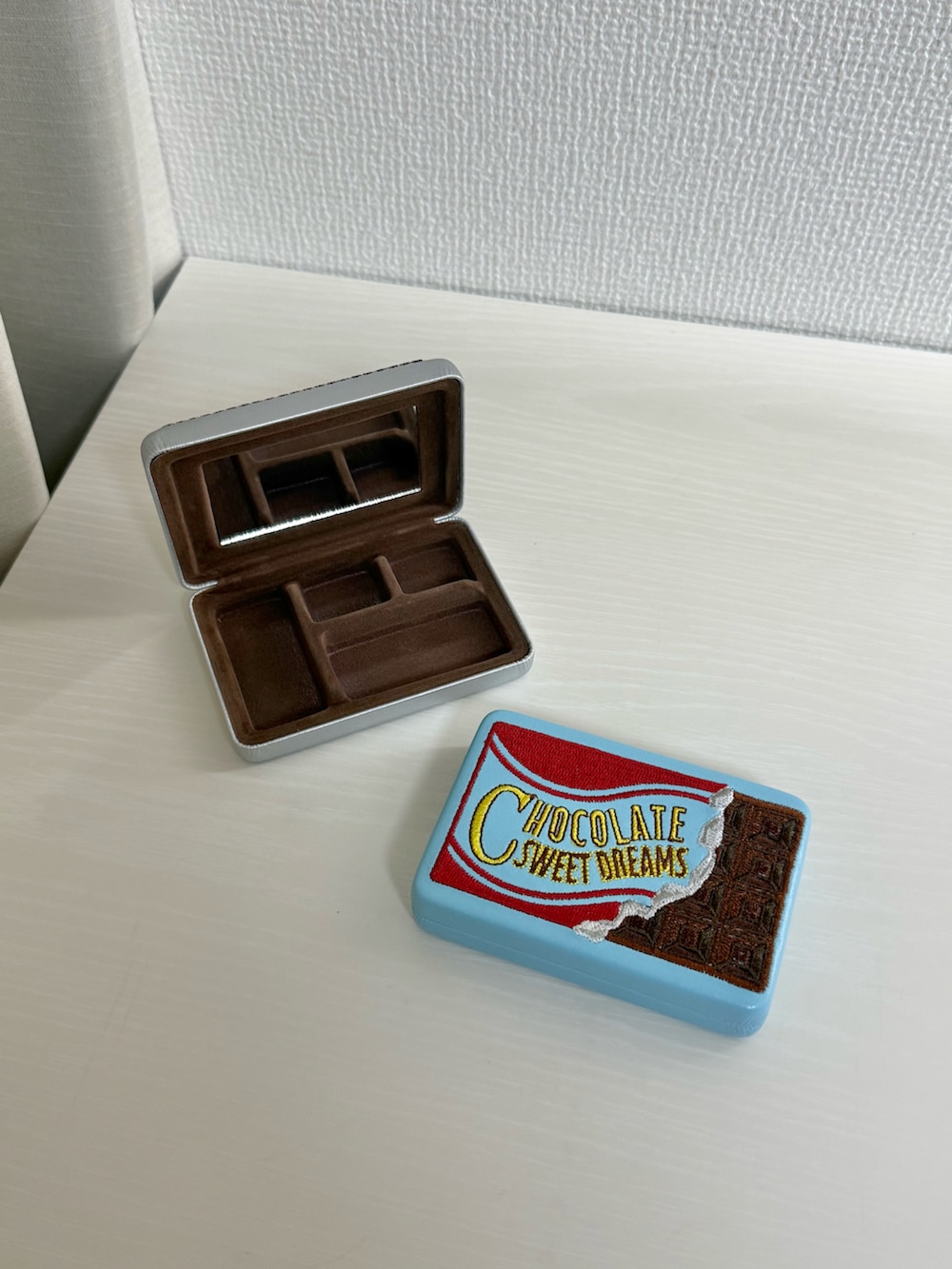 グレー系のトートバッグ、レッド系のハンドケア/ハンドクリーム、ブルー系のポーチを着用したレディースの冬コーディネートの3枚目の写真